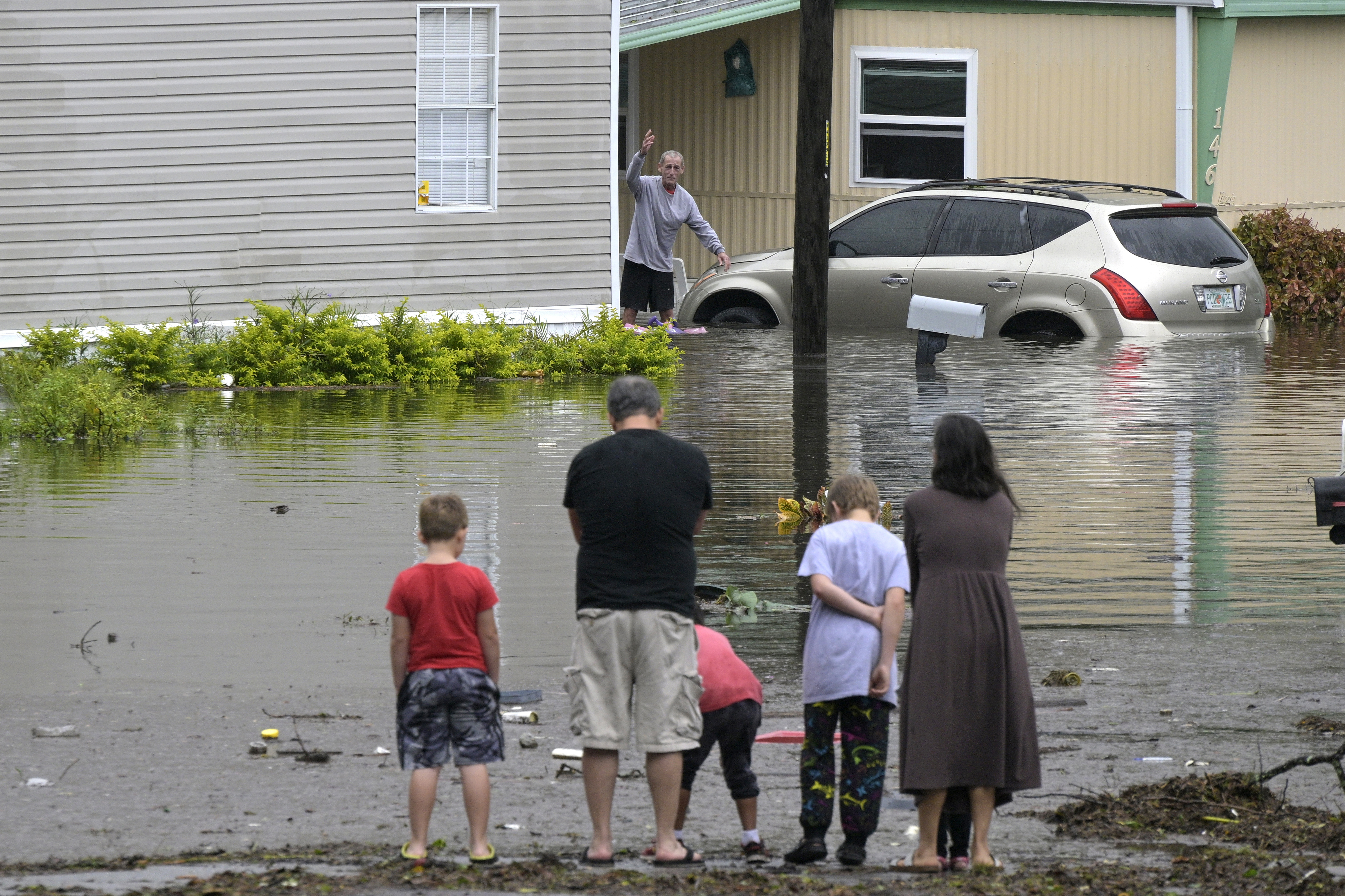 Los residentes se comprueban unos a otros en un barrio inundado tras el paso del huracán Ian, el jueves 29 de septiembre de 2022, en Orlando, Florida (AP Photo/Phelan M. Ebenhack)