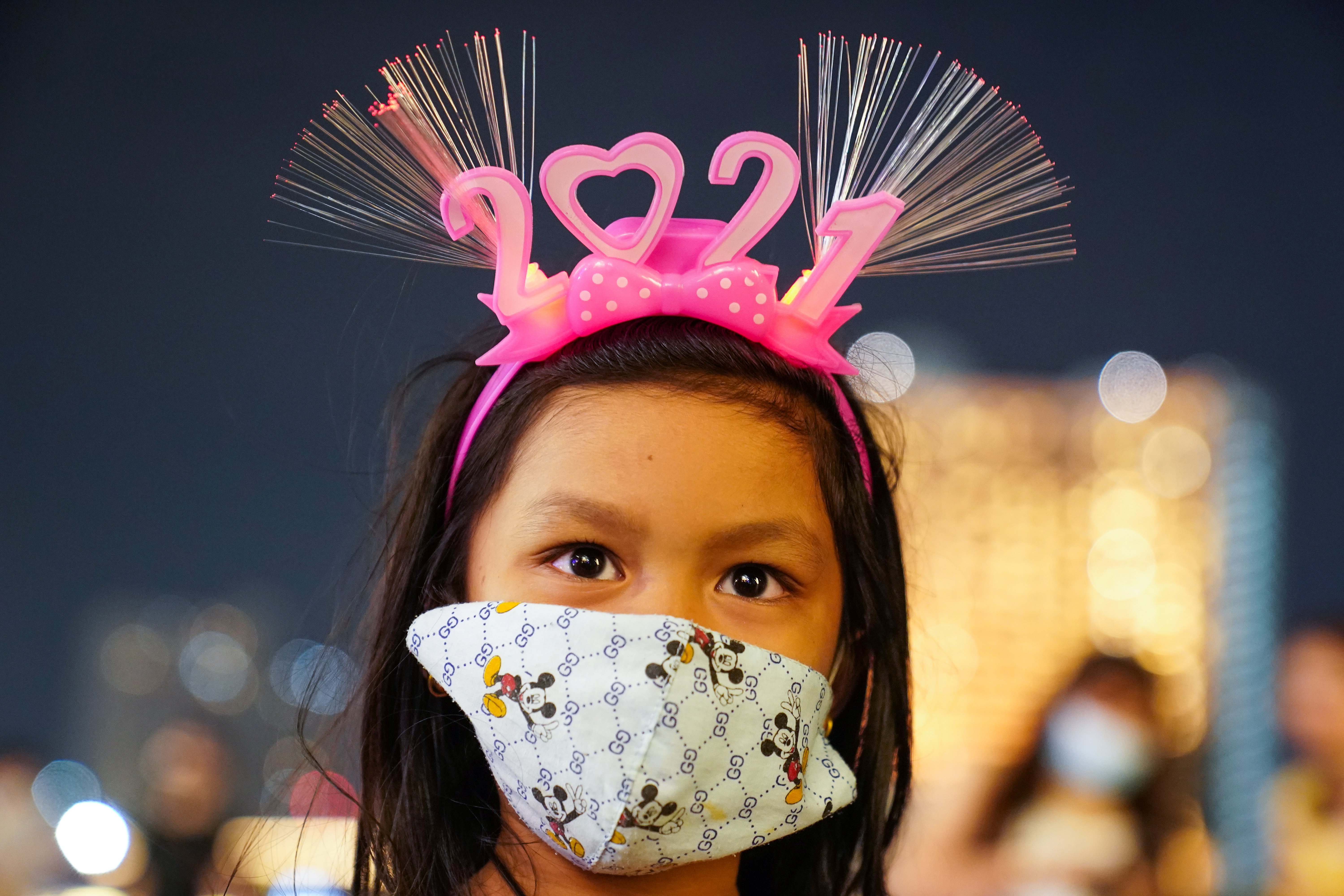 Una niña con mascarilla espera la llegada del 2021 en Bangkok, Tailandia (Reuters/ Athit Perawongmetha)