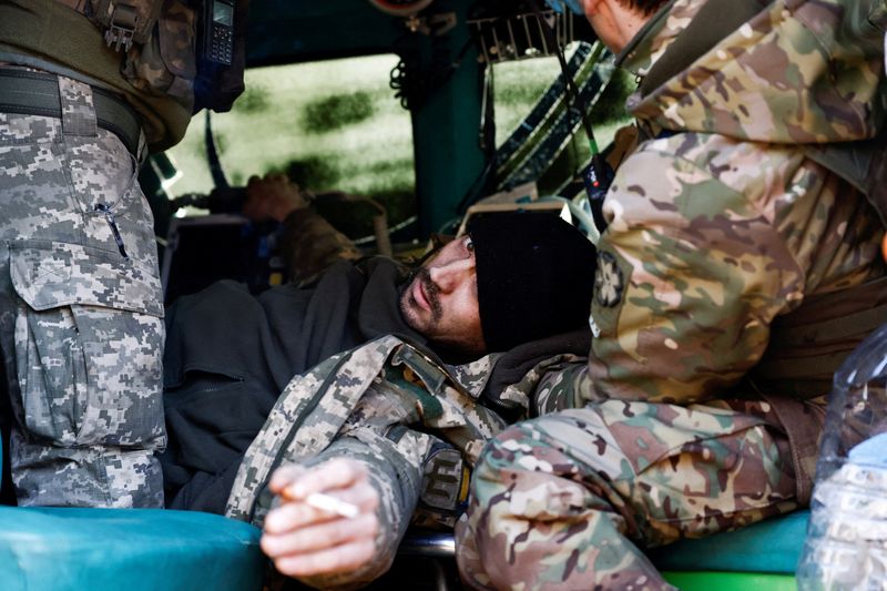 Un soldado ucraniano herido reacciona mientras es tratado por los médicos dentro de una ambulancia de estabilización de primera línea, en medio del ataque de Rusia a Ucrania, en un lugar no revelado cerca de la ciudad de primera línea de Kreminná. REUTERS/Violeta Santos Moura