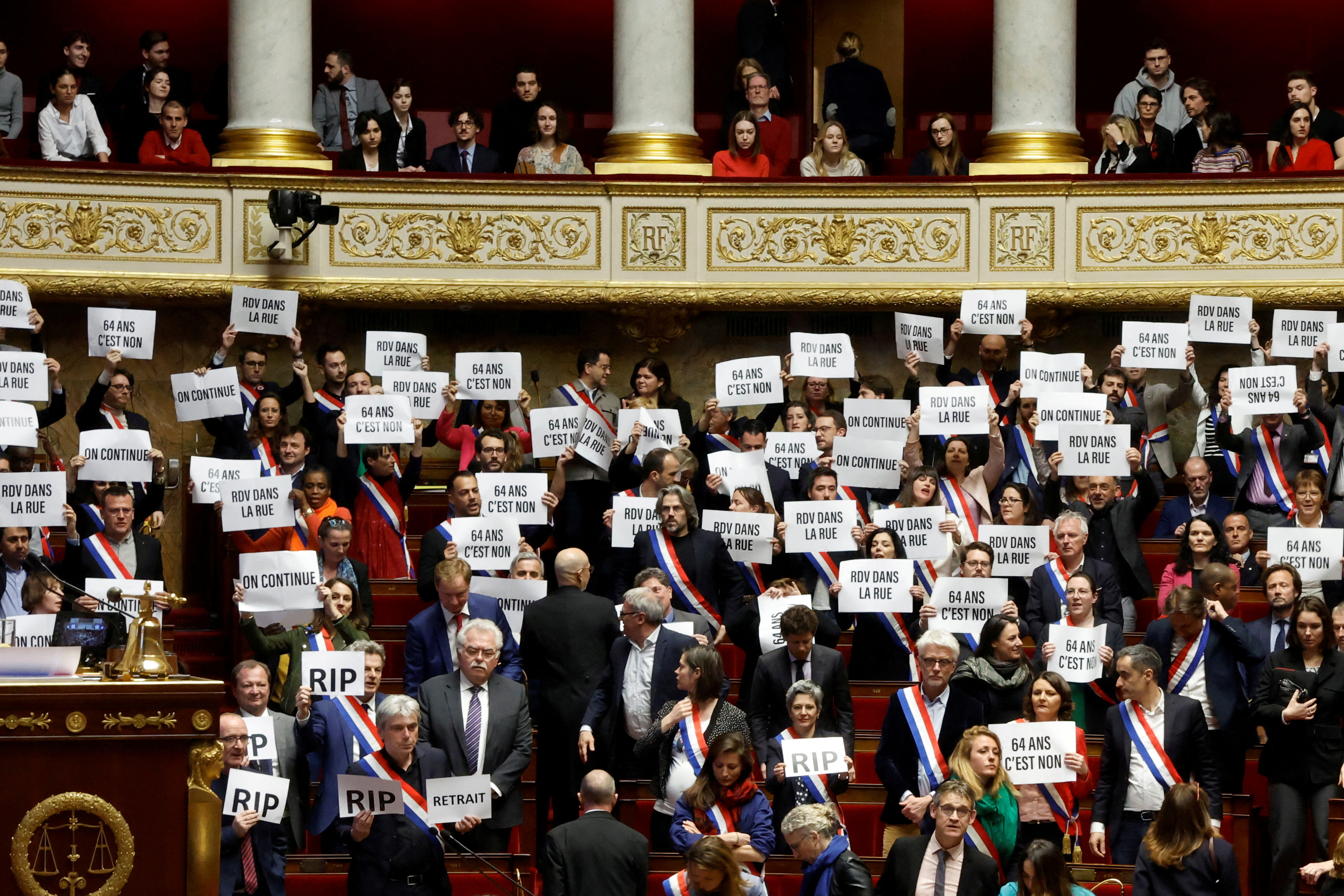 Miembros del parlamento de la izquierda sostienen pancartas tras el resultado de la votación de la primera moción de censura contra el gobierno francés, en la Asamblea Nacional en París, Francia, 20 de marzo de 2023. REUTERS/Gonzalo Fuentes 
