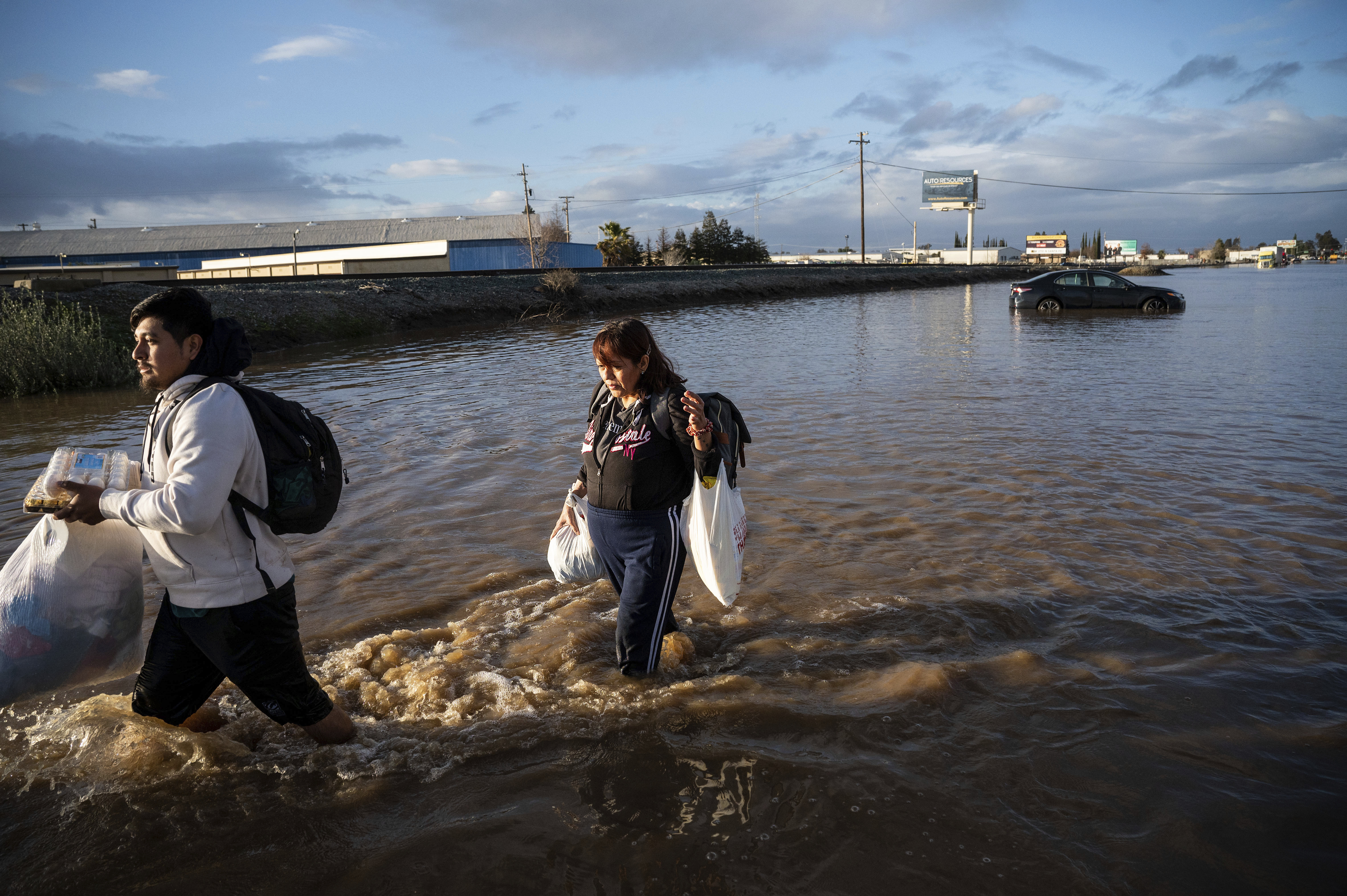 Angeles Molina camina entre el agua en Merced, California, uno de los lugares más afectados