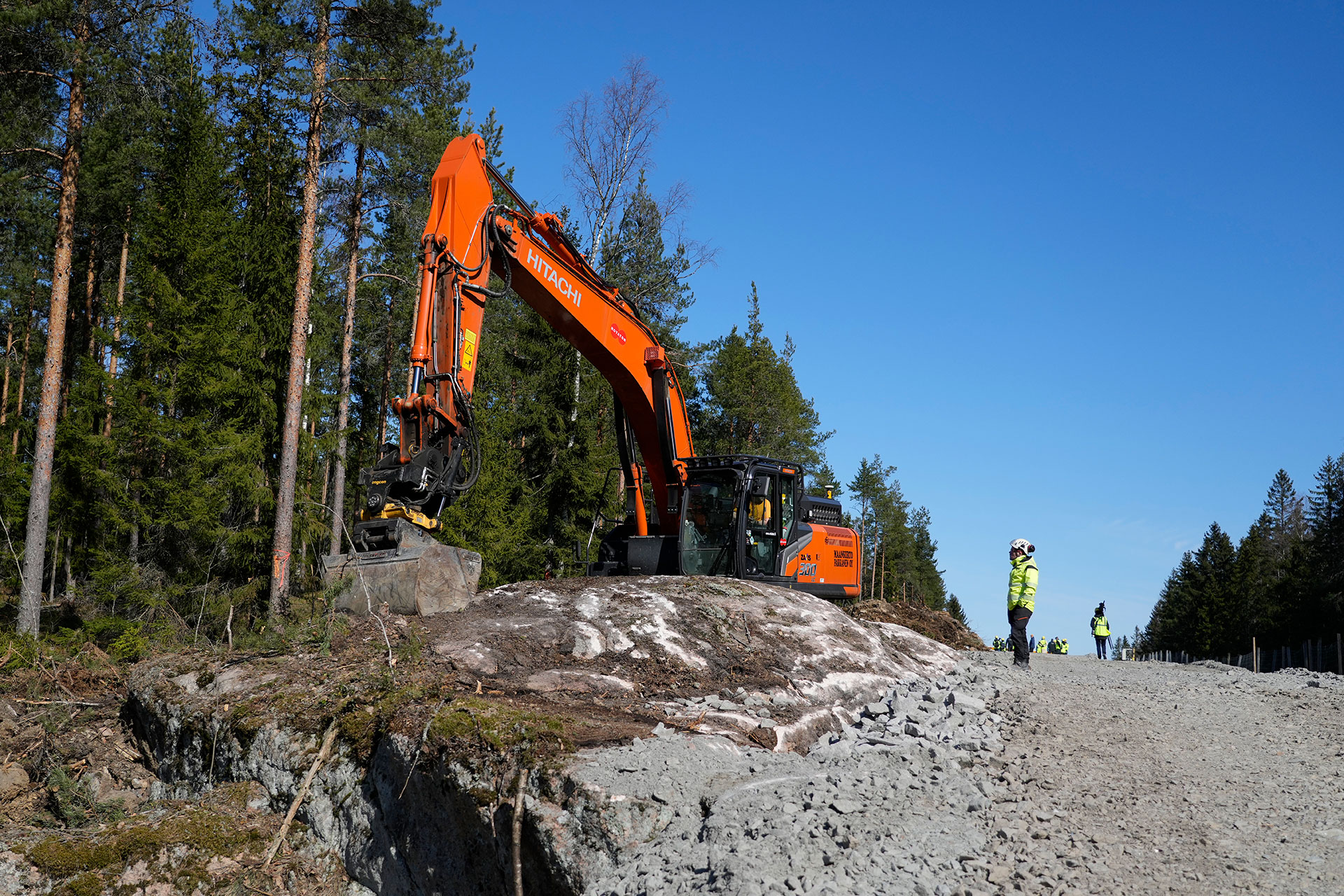 Una excavadora trabaja en la construcción de la valla fronteriza entre Finlandia, a la izquierda, y Rusia cerca del paso fronterizo de Pelkola en Imatra, al sureste de Finlandia, el viernes 14 de abril de 2023. (AP Photo/Sergei Grits)