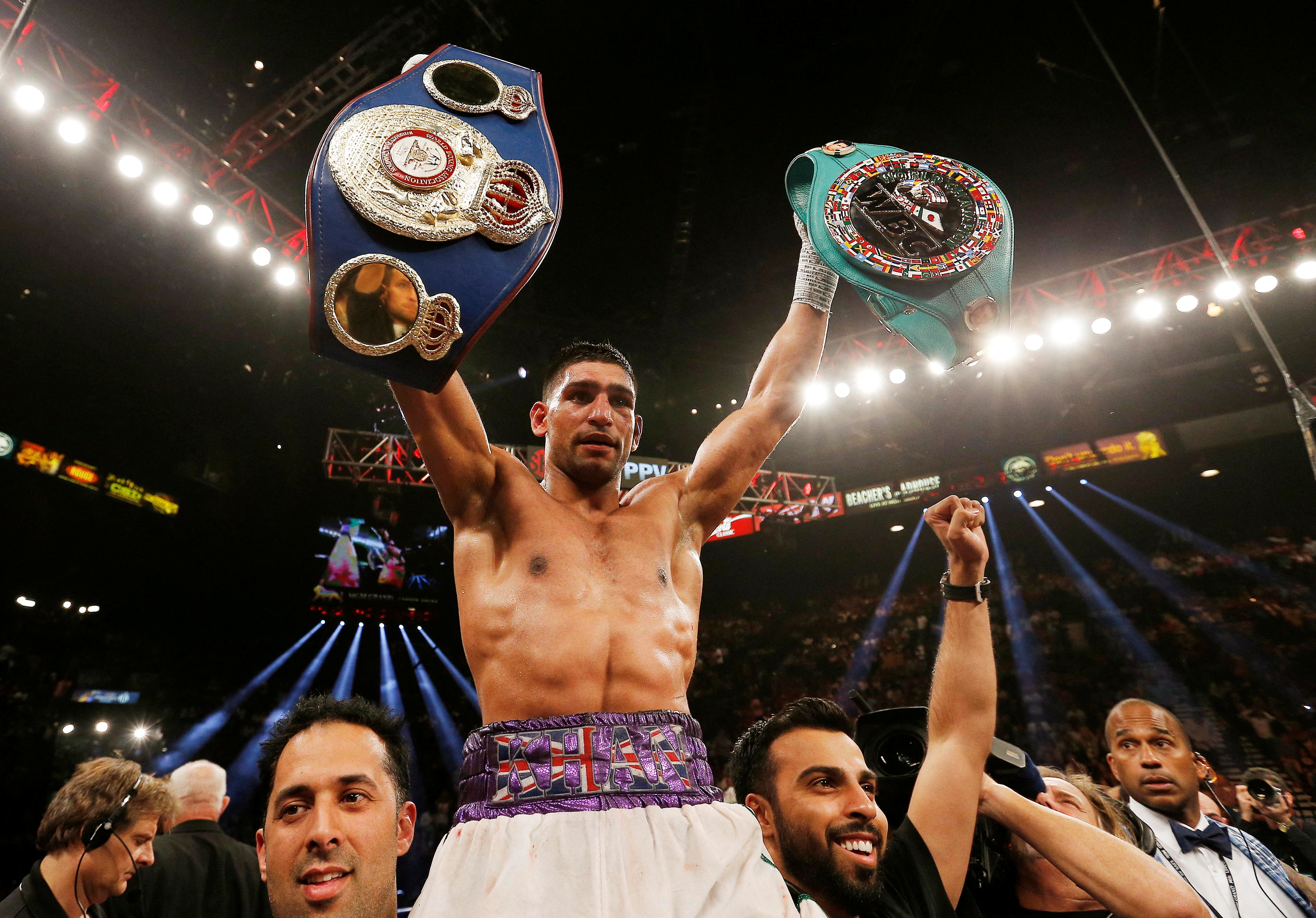 FILE PHOTO: Boxing - Luis Collazo v Amir Khan WBA International Welterweight Title - MGM Grand Garden Arena, Las Vegas, United States of America - 3/5/14   Amir Khan celebrates winning the fight with the title belts   Action Images via Reuters/Andrew Couldridge/File Photo