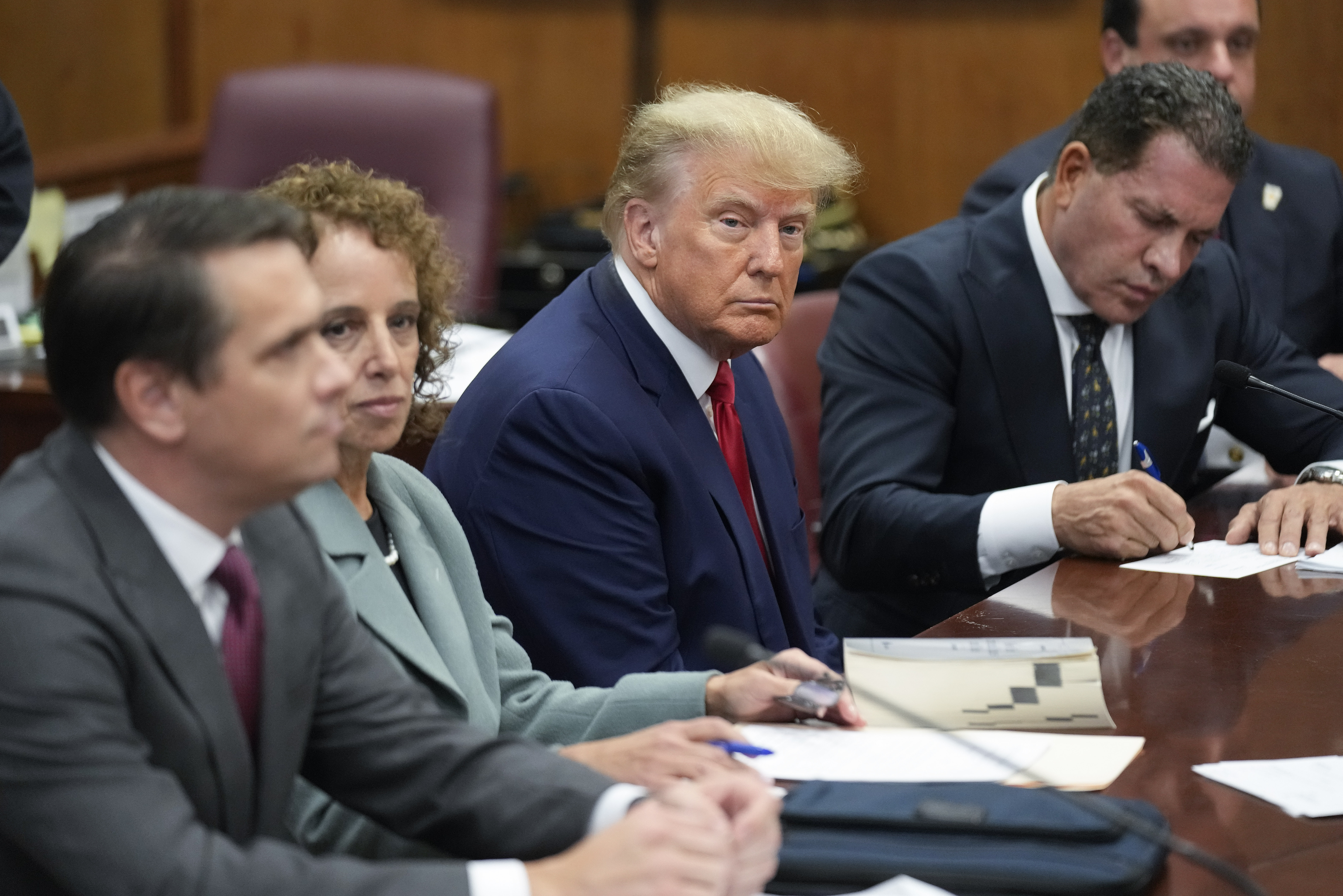 El ex presidente Donald Trump, sentado junto a su equipo de abogados en una sala del tribunal de Manhattan (AP Photo/Seth Wenig)