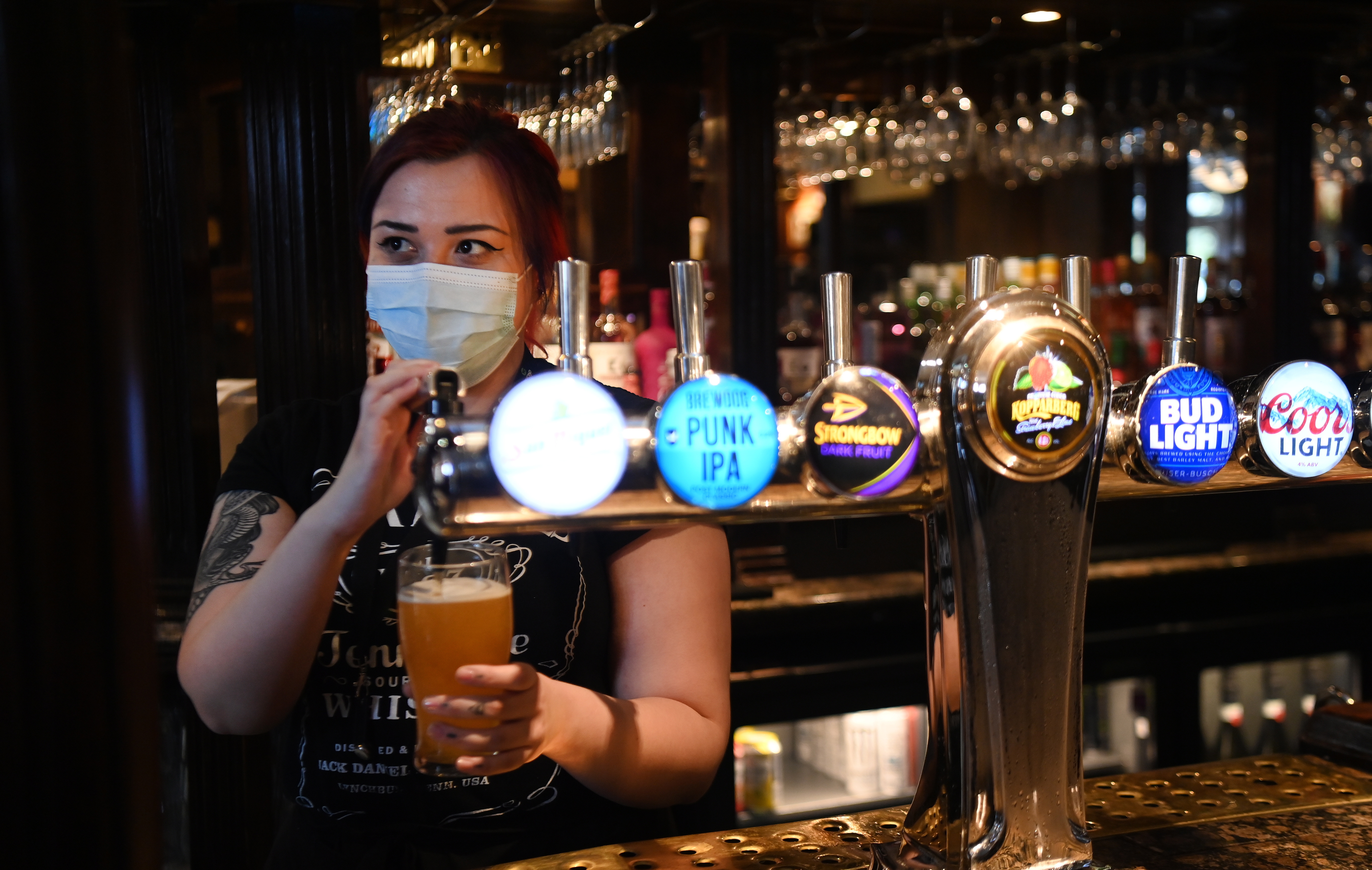 Fotografía de archivo en la que se observa a una empleada sirviendo una cerveza en un bar. (Foto: EFE)