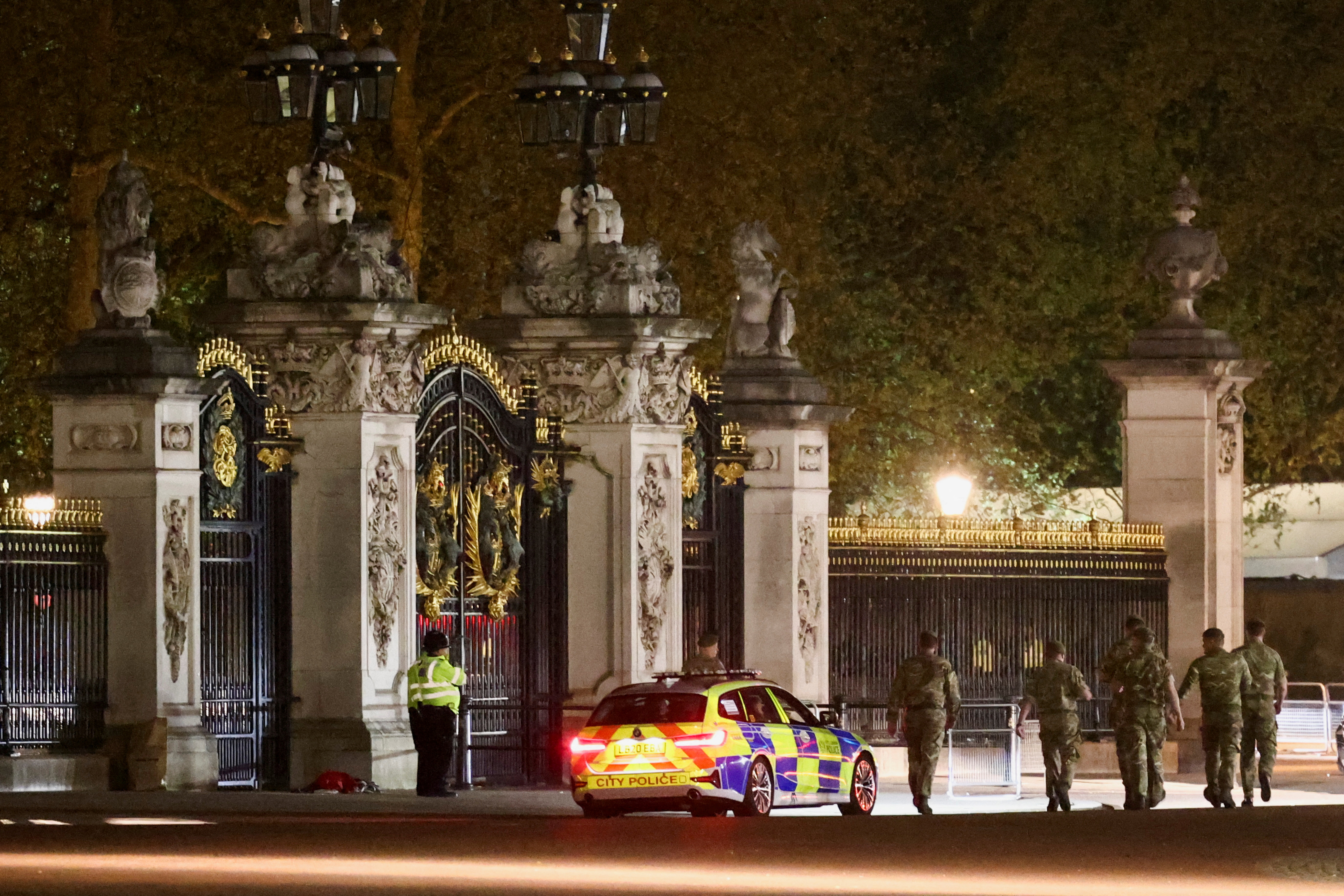 Miembros de la policía y fuerzas de seguridad hacen guardia en las puertas del Palacio de Buckingham  (REUTERS/Henry Nicholls)