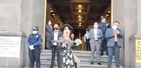 En pleno 8M, una mujer portando una escopeta falsa y una toga magistral lanzó insultos en contra de la ministra Norma Piña  (Captura/Twitter/AlexMonroy4e)