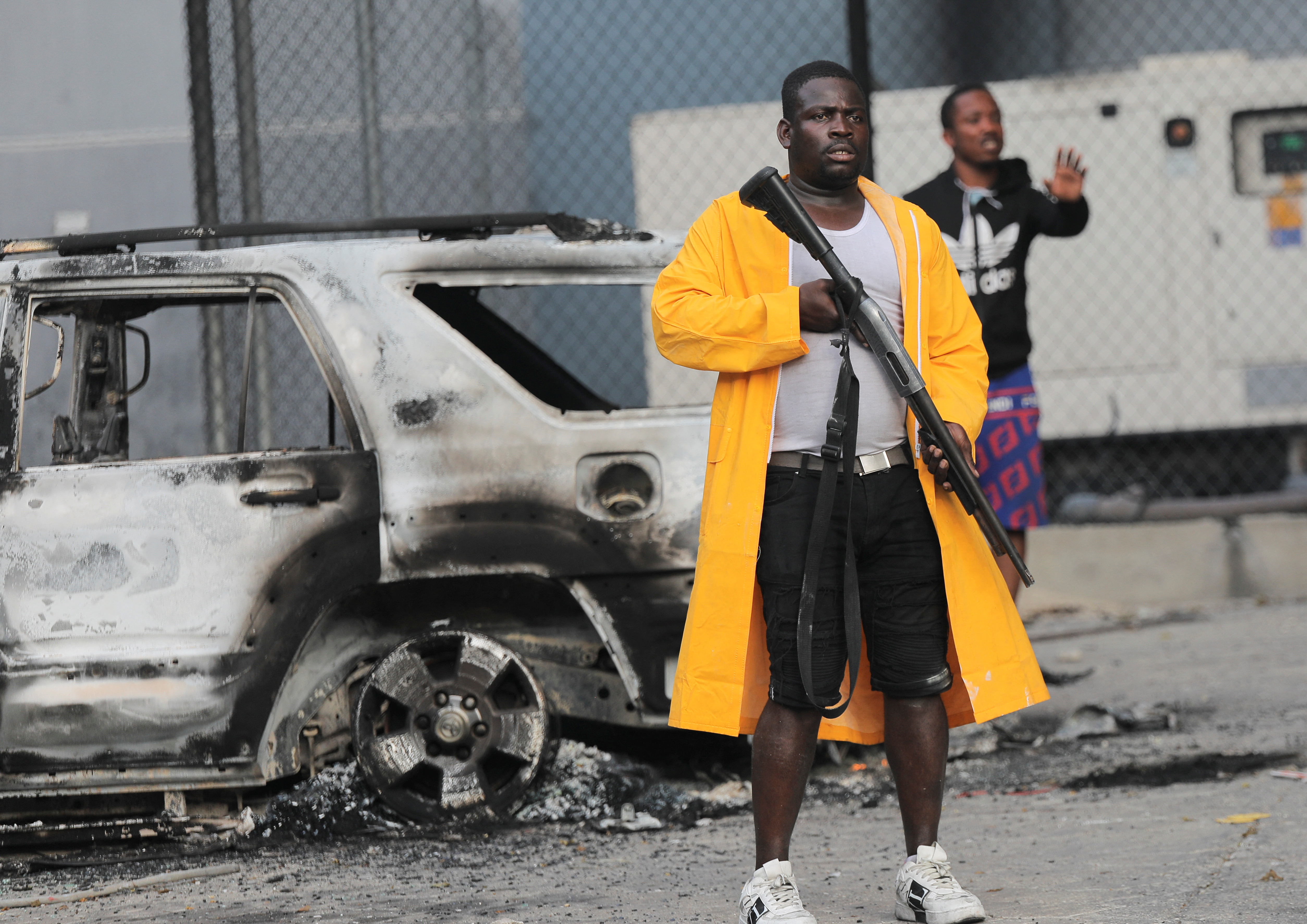 Un hombre armado se encuentra cerca de un coche quemado durante las protestas por el aumento de los precios del combustible y la delincuencia mientras la inflación se dispara a su nivel más alto en una década, en Puerto Príncipe, Haití, el 14 de septiembre de 2022. REUTERS/Ralph Tedy Erol