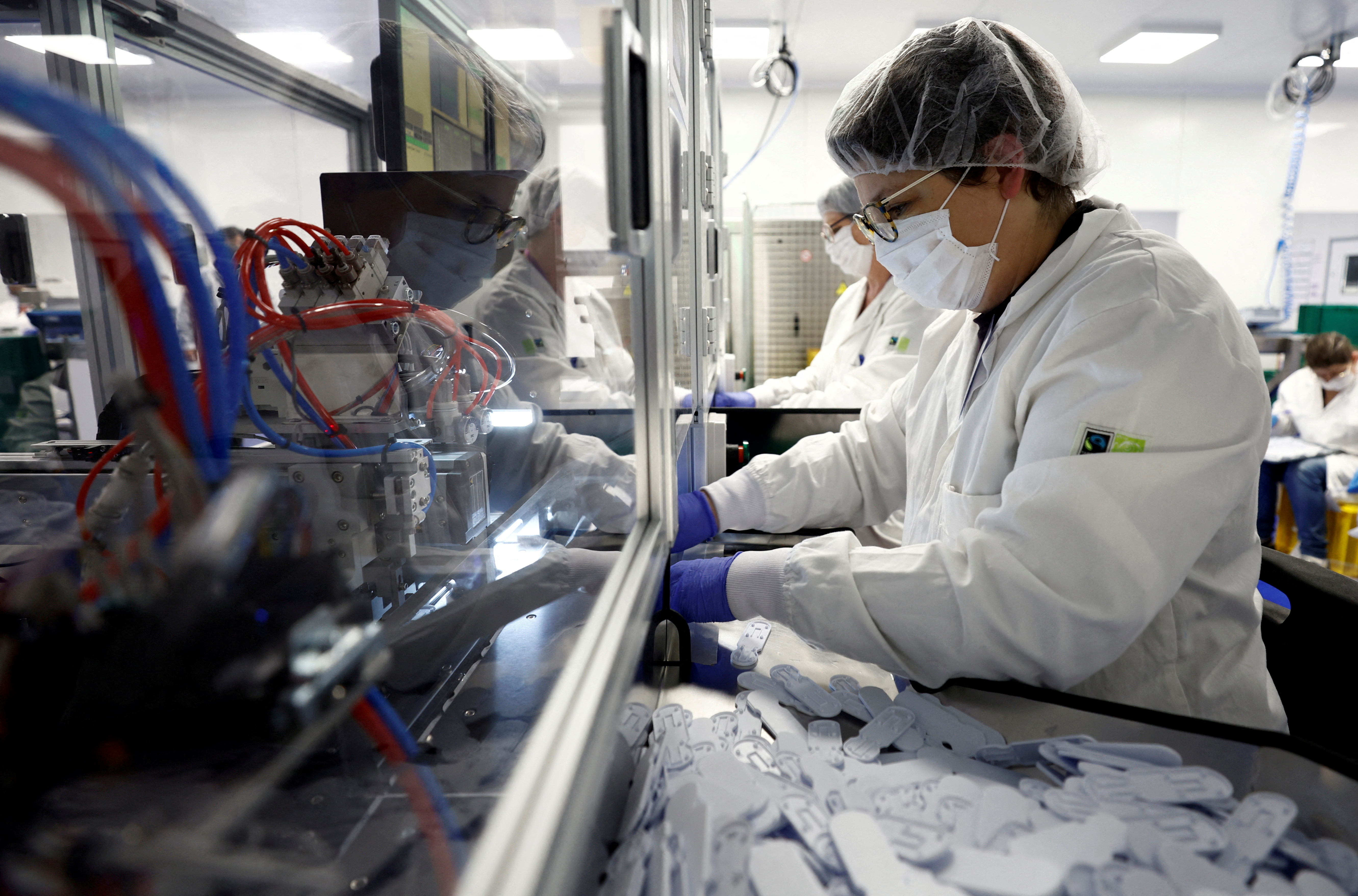 Empleados en una fábrica de test de COVID trabajan creando nuevos productos para satisfacer la demanda ante el crecimiento de las pruebas caseras.(REUTERS/Stephane Mahe/File Photo)