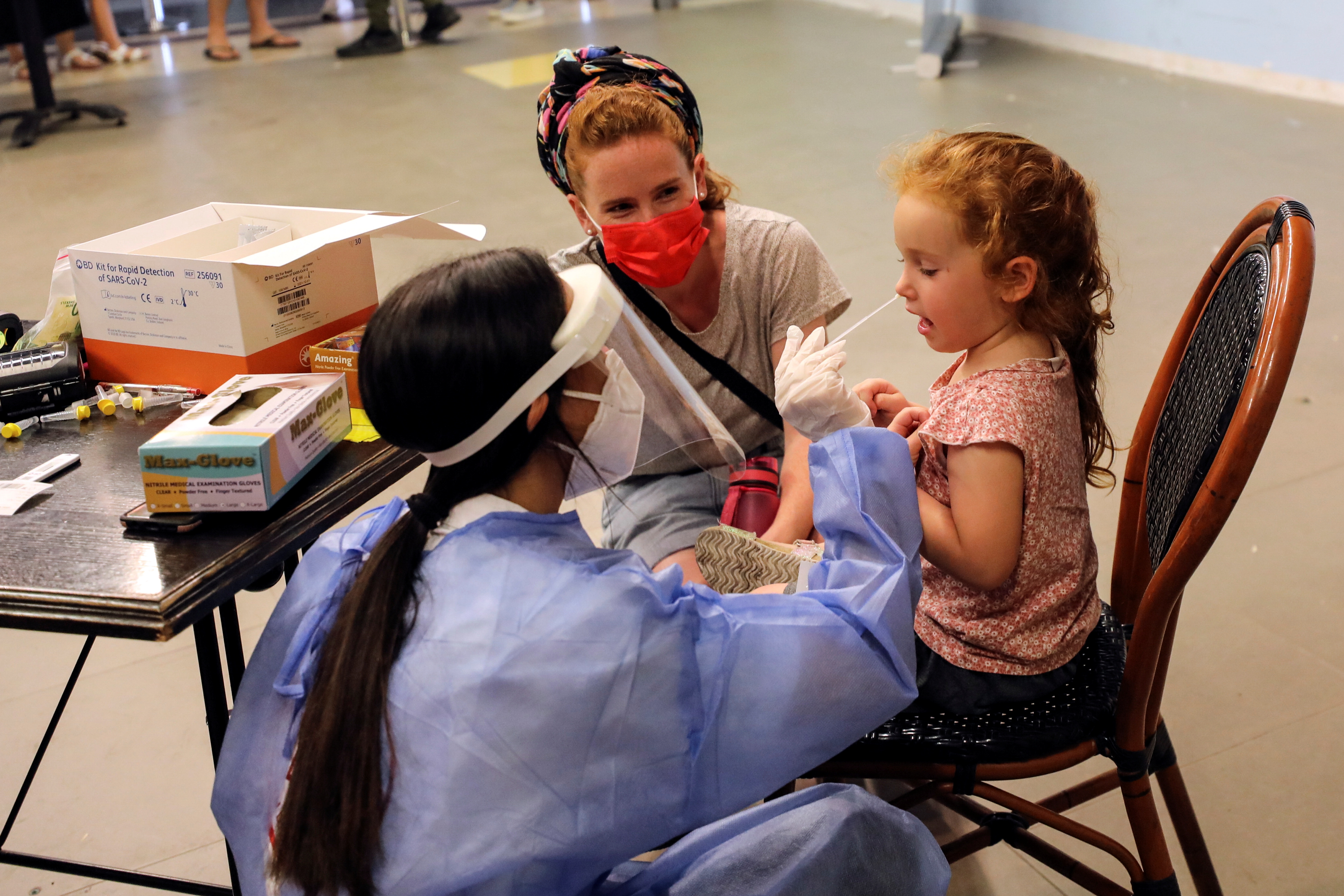 Un trabajador de la salud hisopa a una niña israelí para la prueba de la enfermedad por coronavirus (COVID-19) en Jerusalén el 24 de agosto de 2021. REUTERS / Ammar Awad