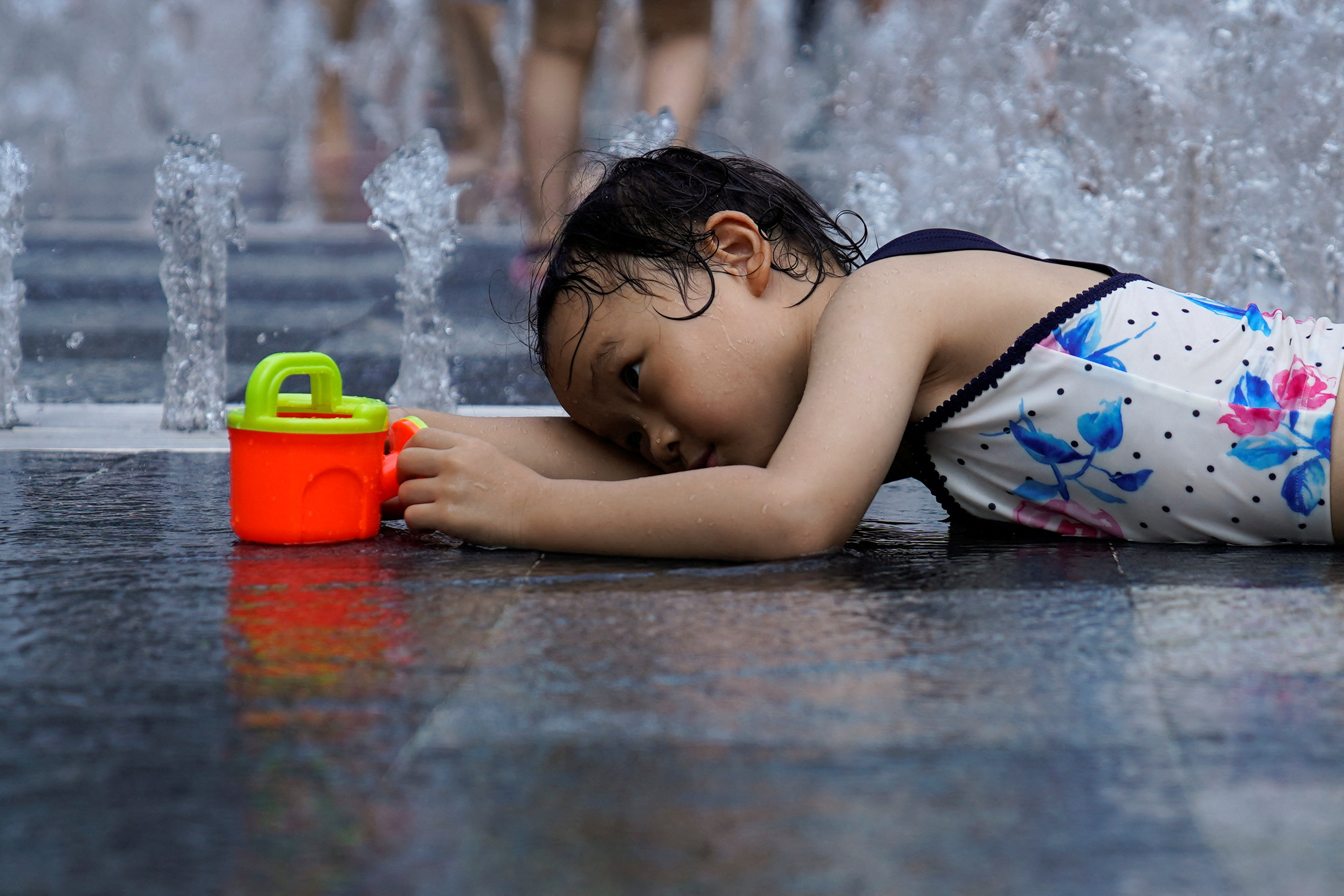 Una niña juega en una fuente en medio de la ola de calor que afecta al país (REUTERS/Aly Song)