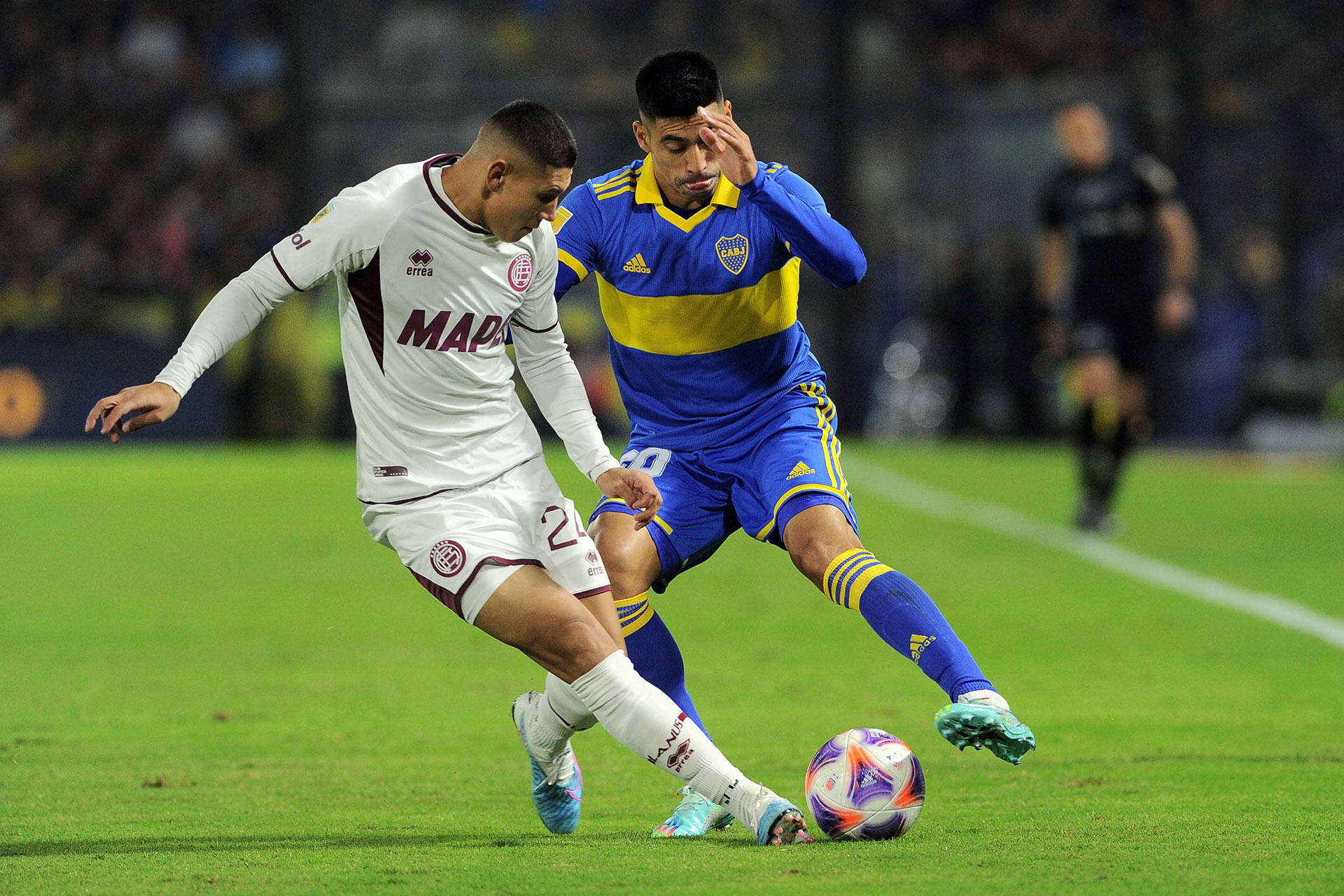 Juan Ramírez, de Boca, intenta quedarse con el balón ante la marca de Juan Cáceres (Télam)