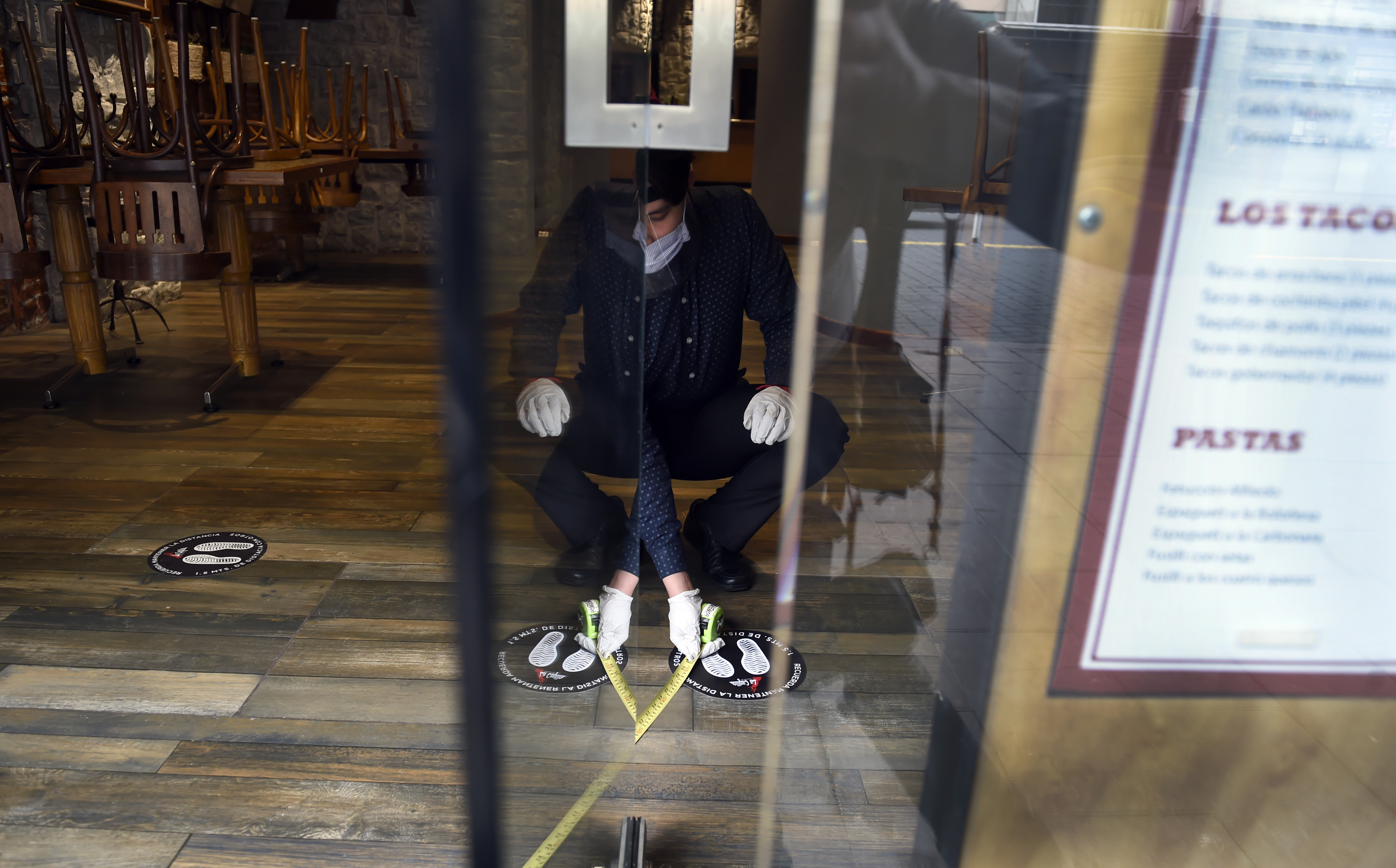 Un empleado del restaurante La Capilla organiza mesas para mantener la distancia social en la Ciudad de México, el 29 de junio de 2020 durante la pandemia COVID-19. (Foto: ALFREDO ESTRELLA / AFP)