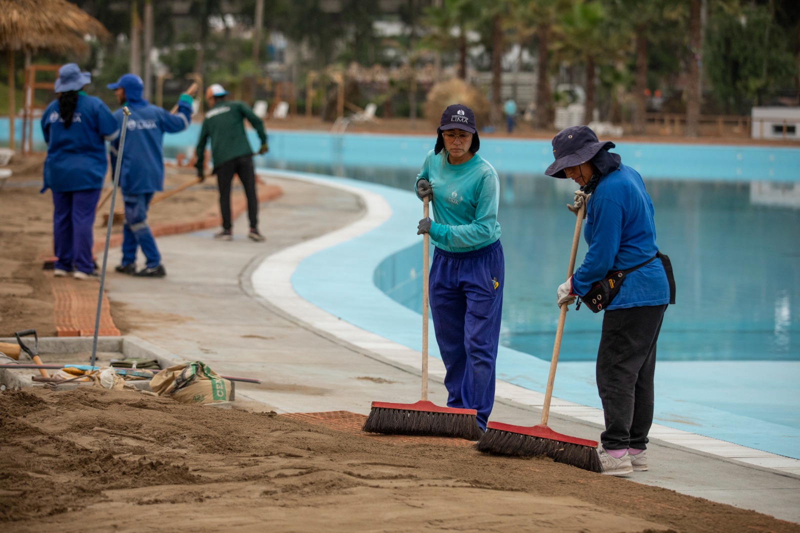 Trabajadores municipales colocan arena fina a proyecto de playa artificial.