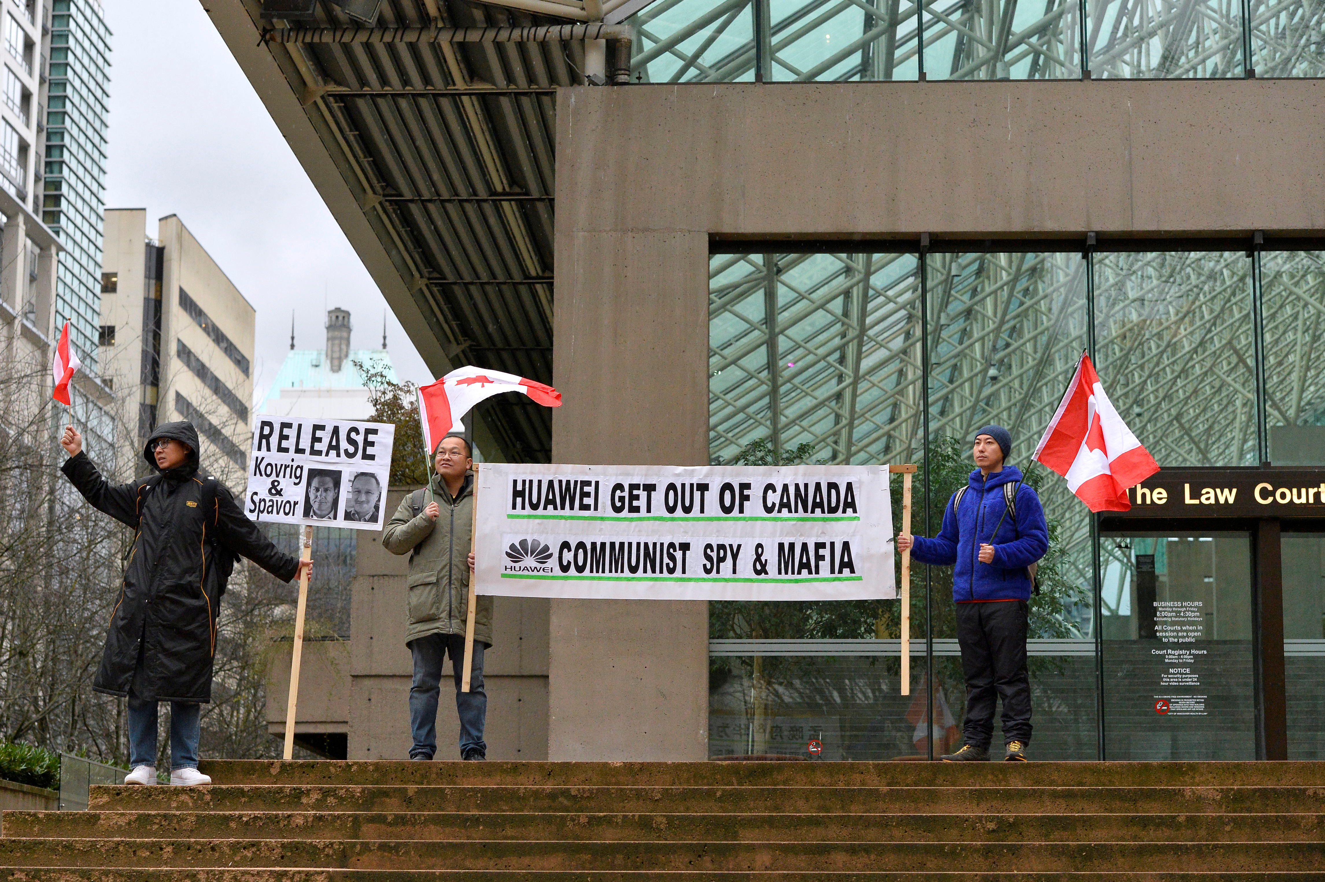 Steven Song, Shengwu Zhu y Zhiyuan Wang sostienen carteles afuera de la Corte en Canadá REUTERS/Jennifer Gauthier