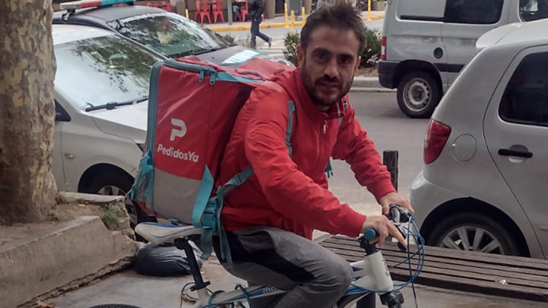 Sobre su bicicleta con la mochila de la aplicación de delivery con que trabaja en las calles de La Plata