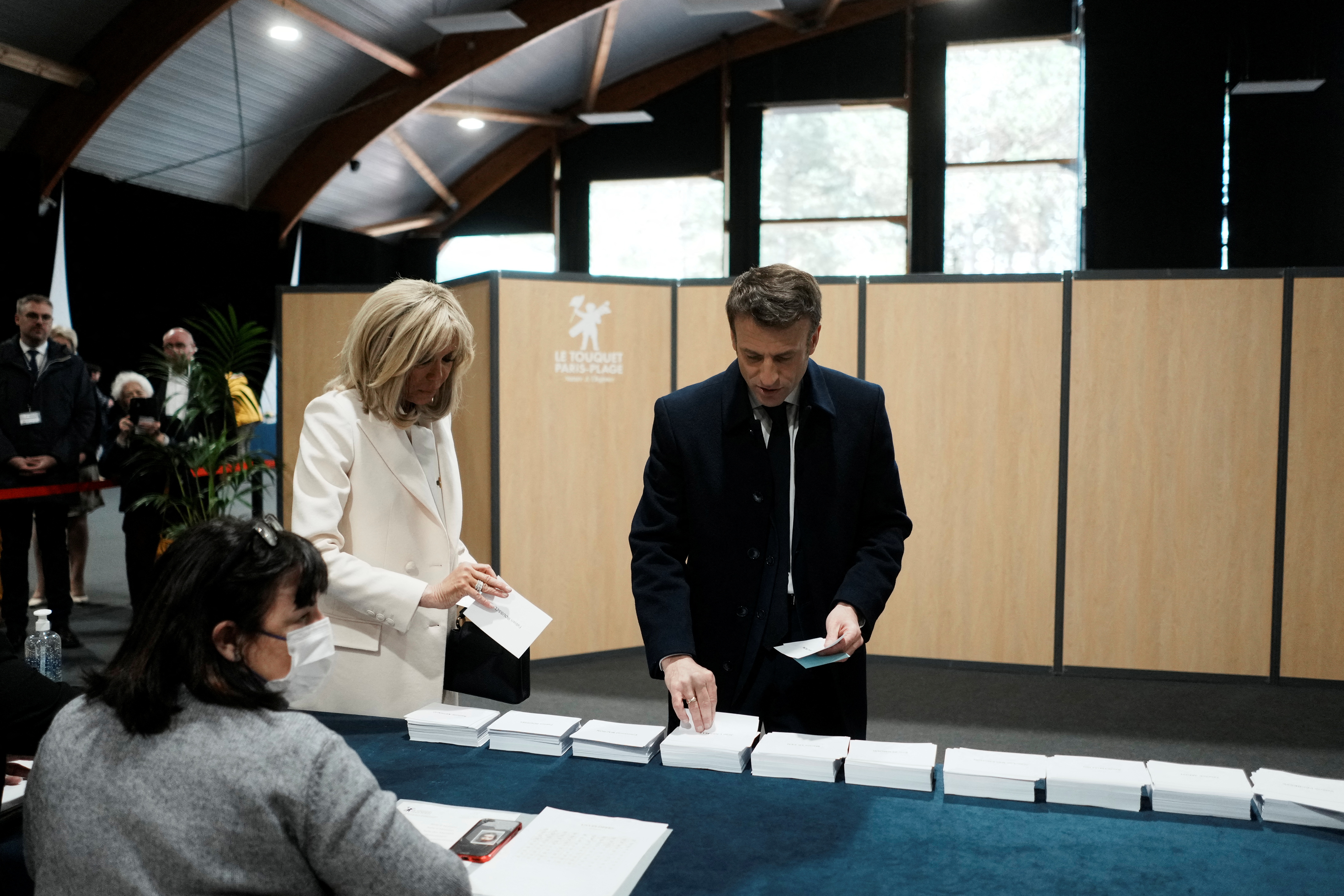 El presidente francés Emmanuel Macron y su esposa Brigitte Macron votan en Le Touquet, norte de Francia 10 de abril de 2022 (REUTERS)