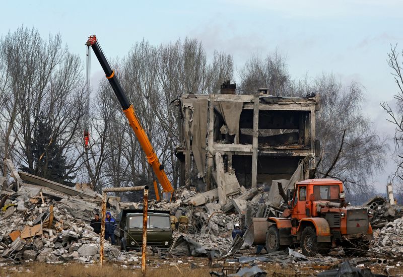 Trabajadores retiran los escombros de un edificio destruido usado como alojamiento temporal para soldados rusos, decenas de los cuales murieron en un ataque con misiles ucranianos, en Makiivka, en Ucrania controlada por Rusia. 4 de enero de 2023 (REUTERS/Alexander Ermochenko)