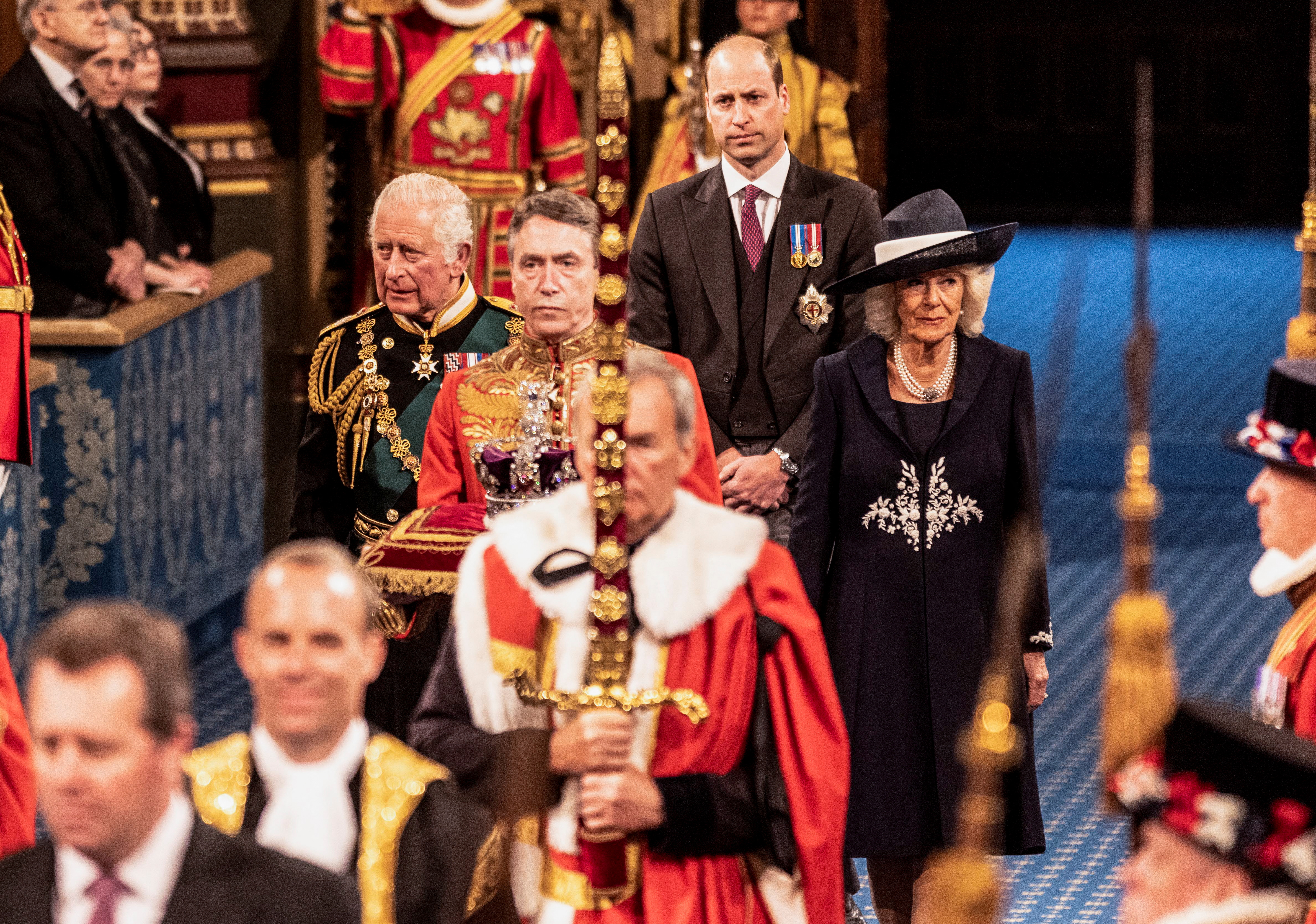 El príncipe Carlos con la duquesa de Cornualles y el príncipe William durante la apertura del Parlamento, en la Cámara de los Lores en Londres, Gran Bretaña, el 10 de mayo de 2022 (Reuters)