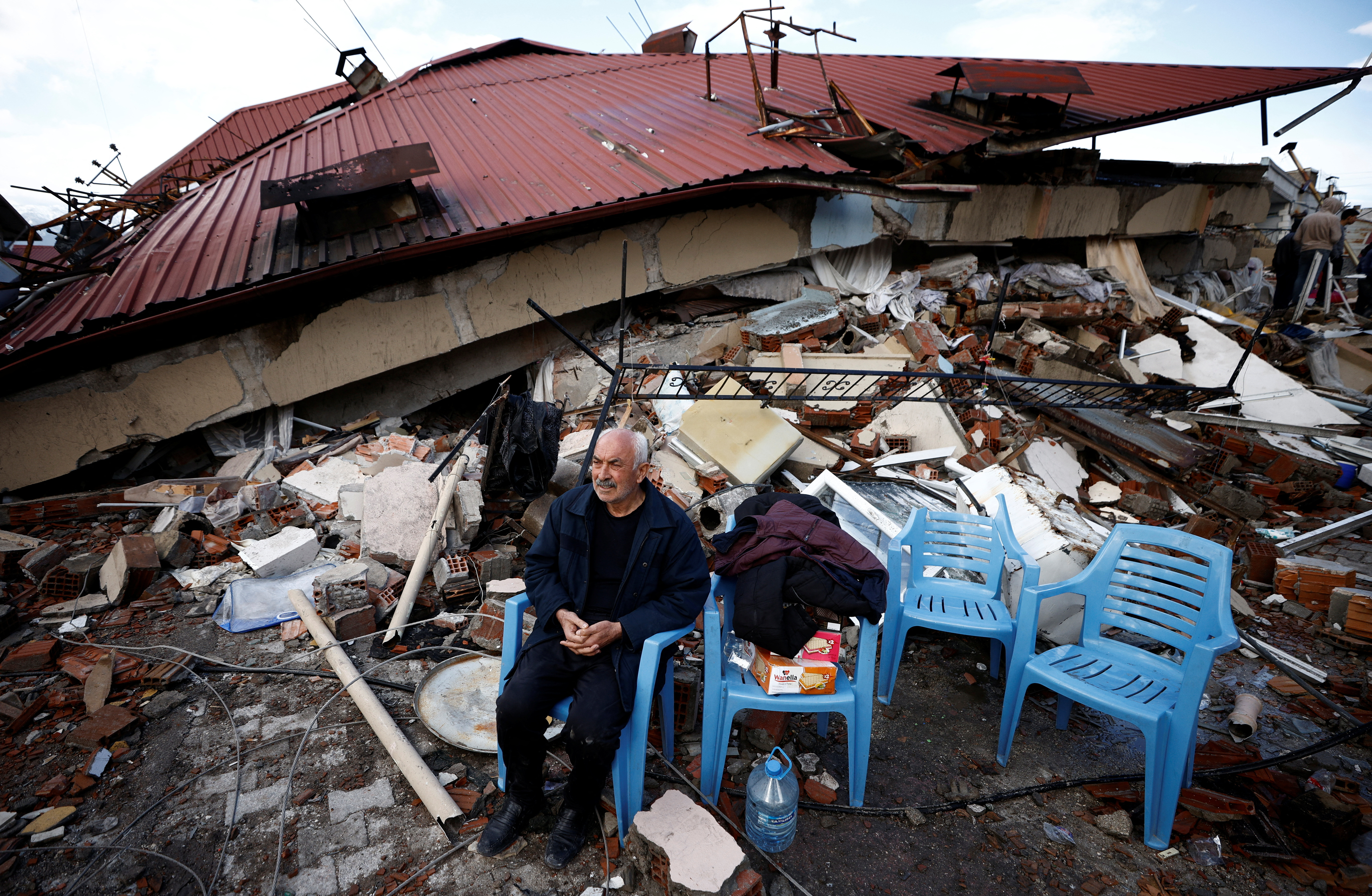 Un hombre sentado sobre los escombros en Hatay (REUTERS/Guglielmo Mangiapane)