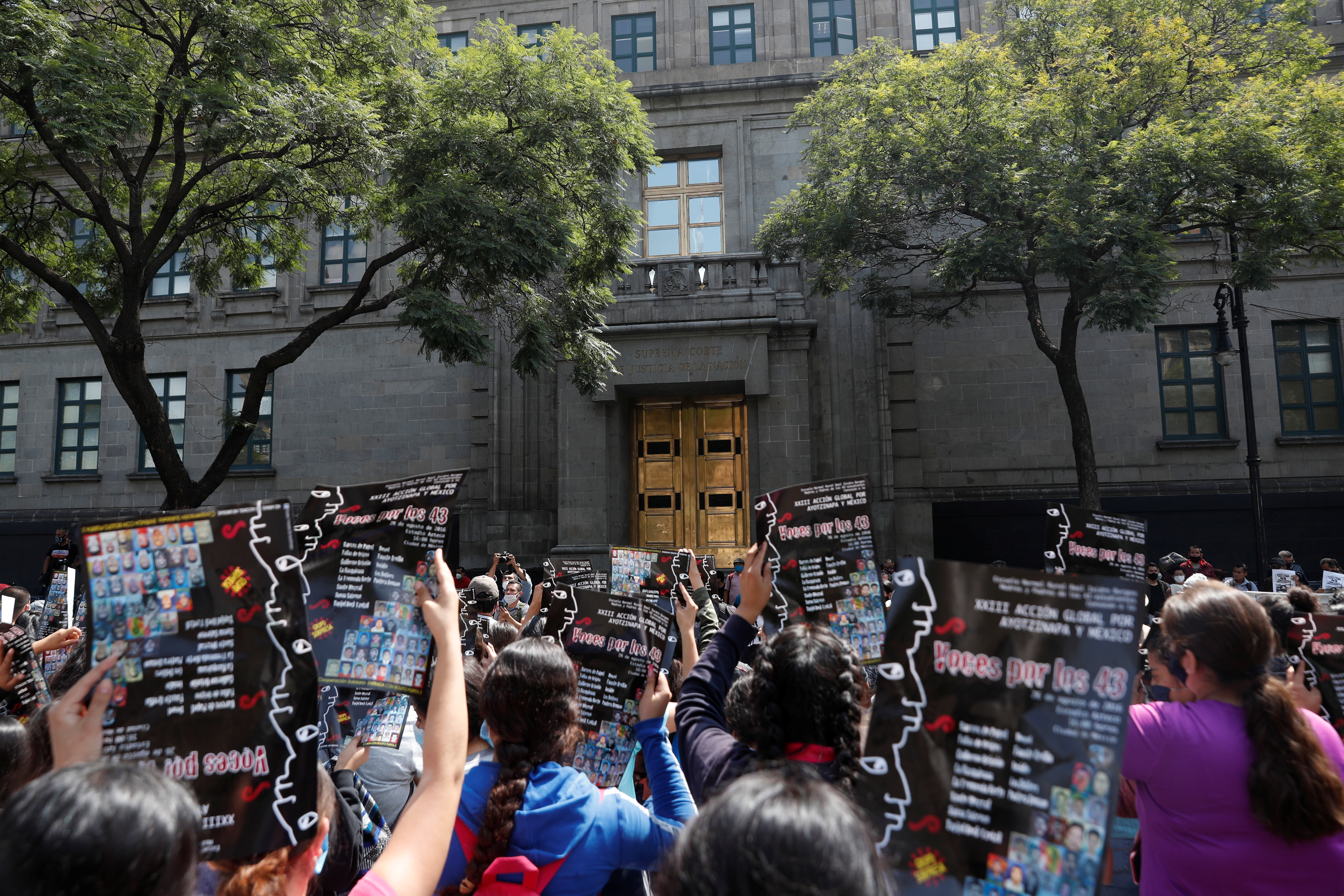 Familiares de estudiantes desaparecidos sostienen carteles durante una protesta frente a la Corte Suprema de Justicia, antes del sexto aniversario de la desaparición de 43 estudiantes de la Escuela Normal Rural de Ayotzinapa, en la Ciudad de México, México 23 de septiembre de 2020.