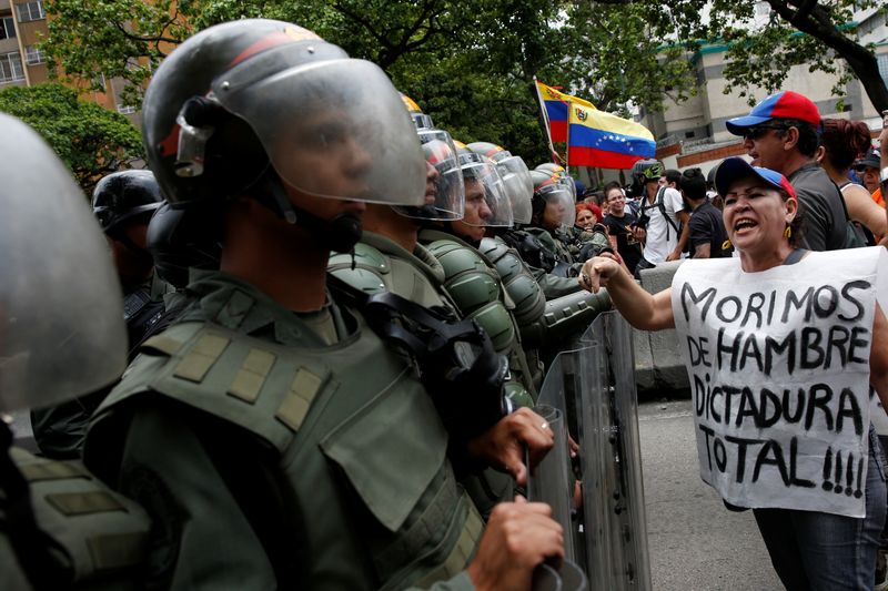 Una opositora grita a un miembro de la Guardia Nacional de Venezuela durante una protesta (REUTERS/Carlos Garcia Rawlins)
