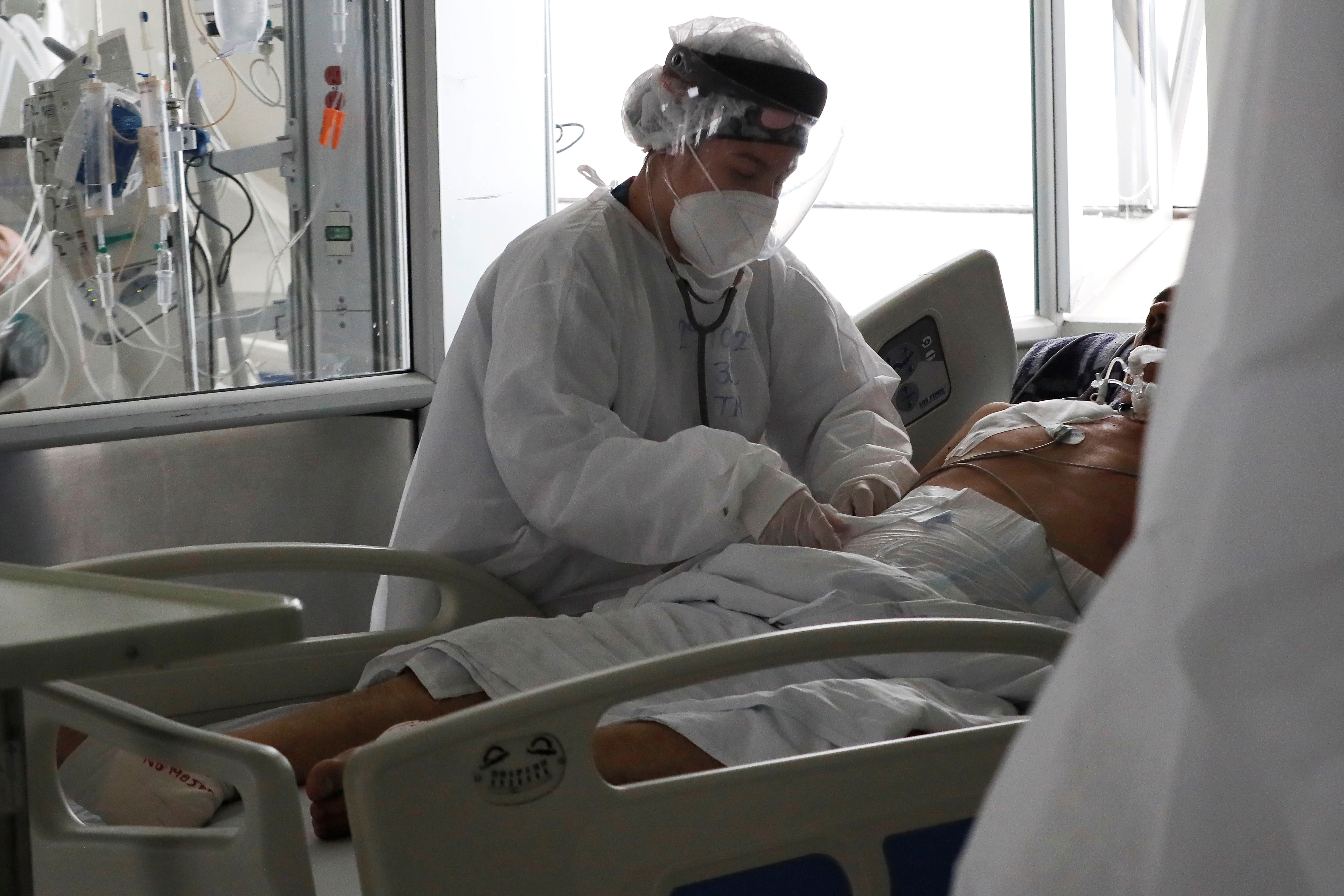 Una empleada de la salud atiende a un paciente en una unidad de cuidados intensivos para enfermos de covid-19 en el Hospital El Tunal, el 30 de abril de 2021 en Bogotá (Colombia). EFE/Carlos Ortega
