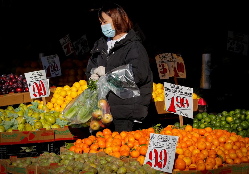 Imagen de archivo de una mujer que utiliza mascarilla y guantes  mientras compra frutas en medio del brote de coronavirus, en Brooklyn, Nueva York, EEUU [11 de mayo de 2020]  (Reuters/ Brendan McDermid)