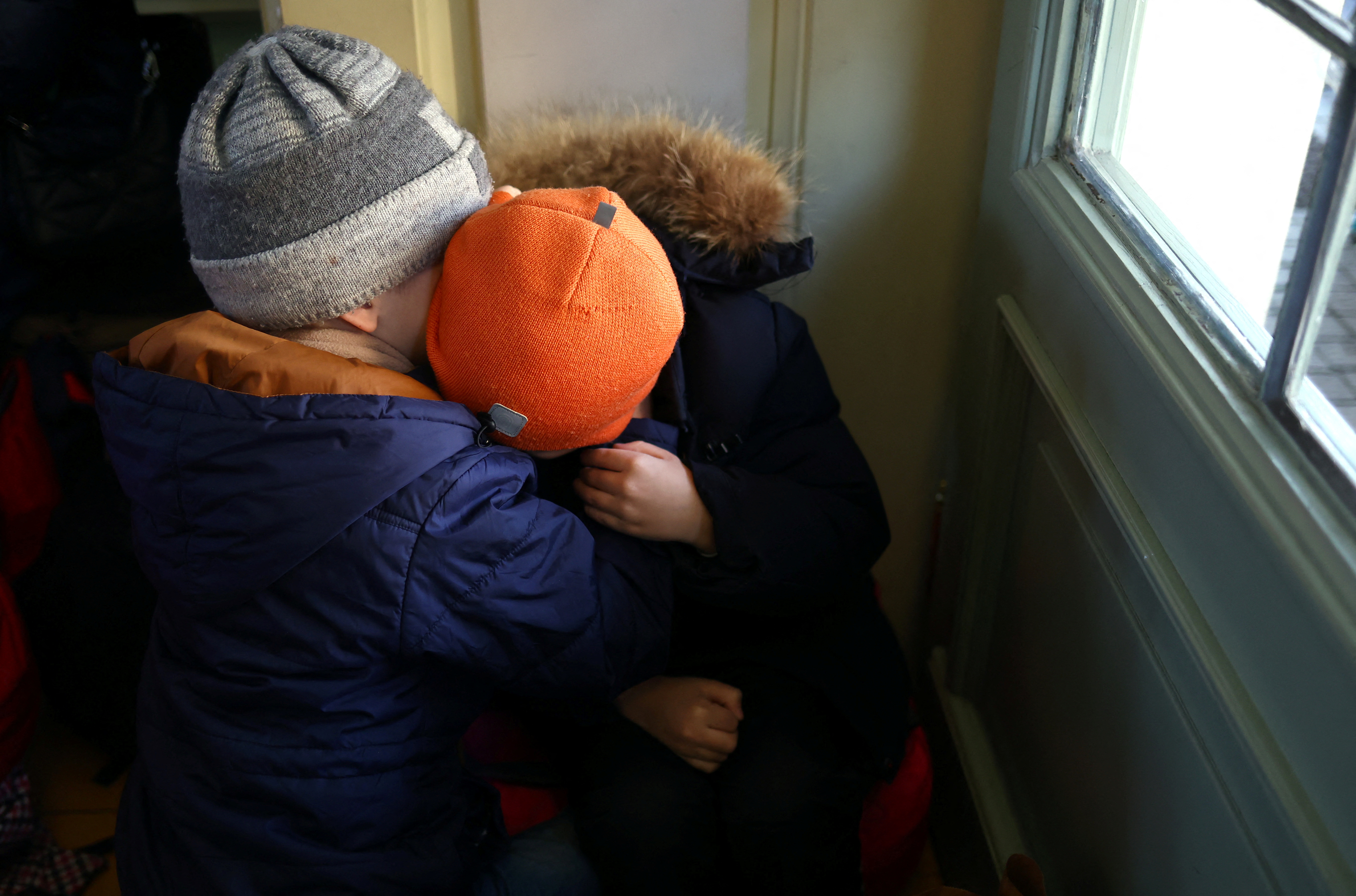 FOTO DE ARCHIVO: Niños refugiados ucranianos se abrazan mientras descansan en el vestíbulo de billetes de la estación de tren de Przemysl Glowny, tras huir de la invasión rusa de Ucrania, en Przemysl, Polonia 24 de marzo de 2022. REUTERS/Hannah McKay