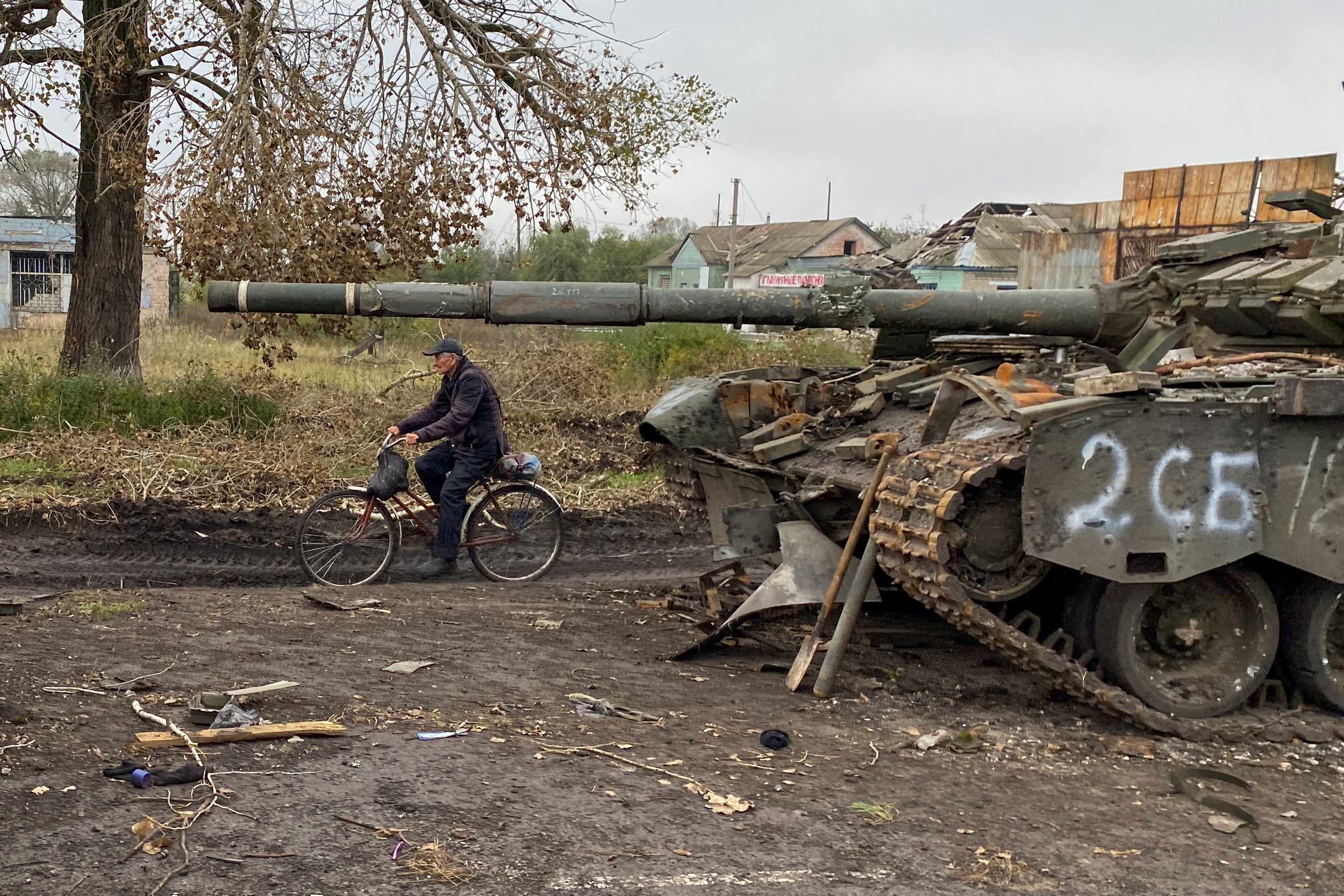 Un residente local pasa en bicicleta por delante de un tanque ruso abandonado en el pueblo de Kurylivka, en la región de Kharkiv, Ucrania 1 de octubre de 2022.  REUTERS/Vitalii Hnidyi