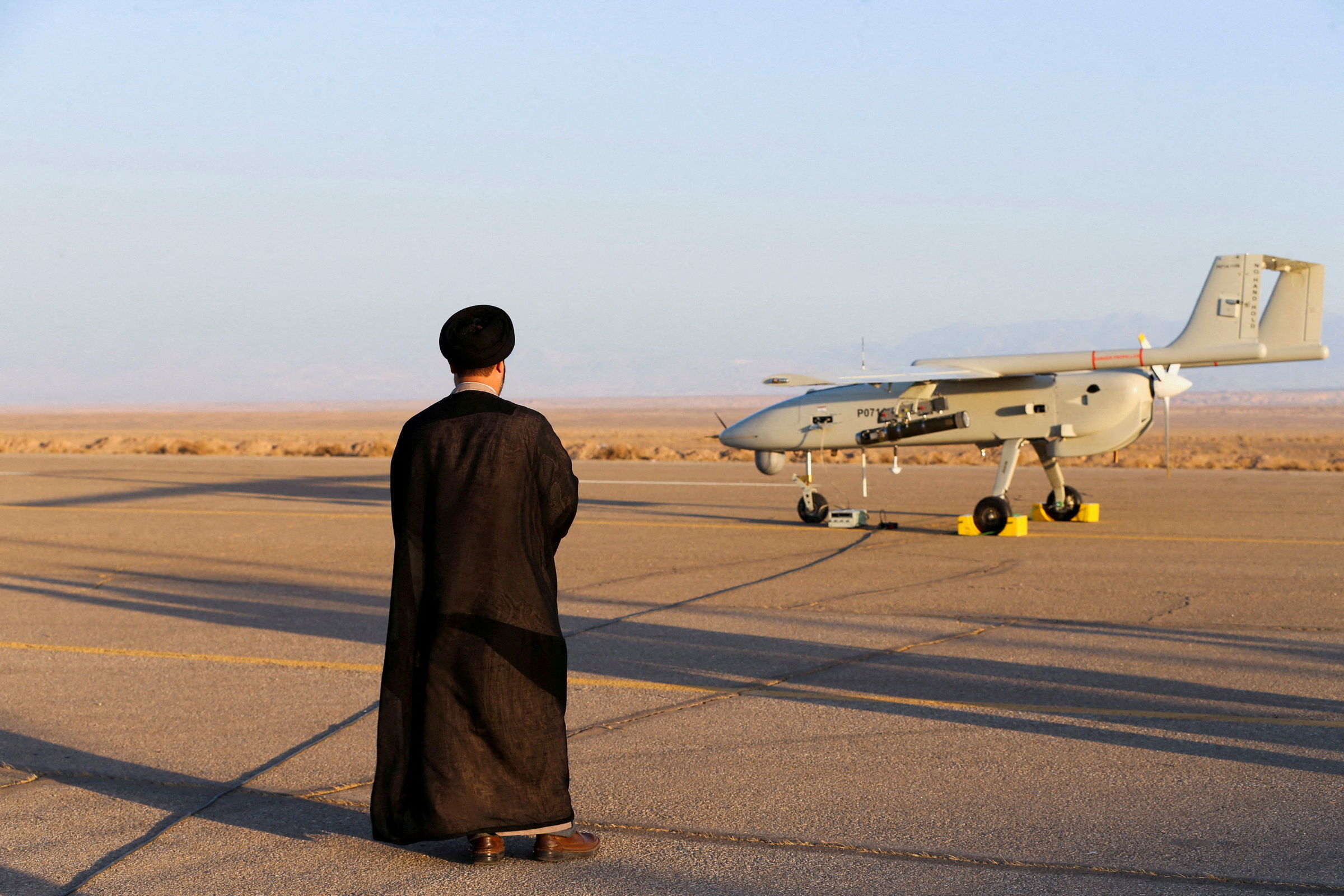 FOTO DE ARCHIVO: Un clérigo iraní se encuentra cerca de un avión no tripulado durante un ejercicio militar en un lugar no revelado en Irán (Reuters)