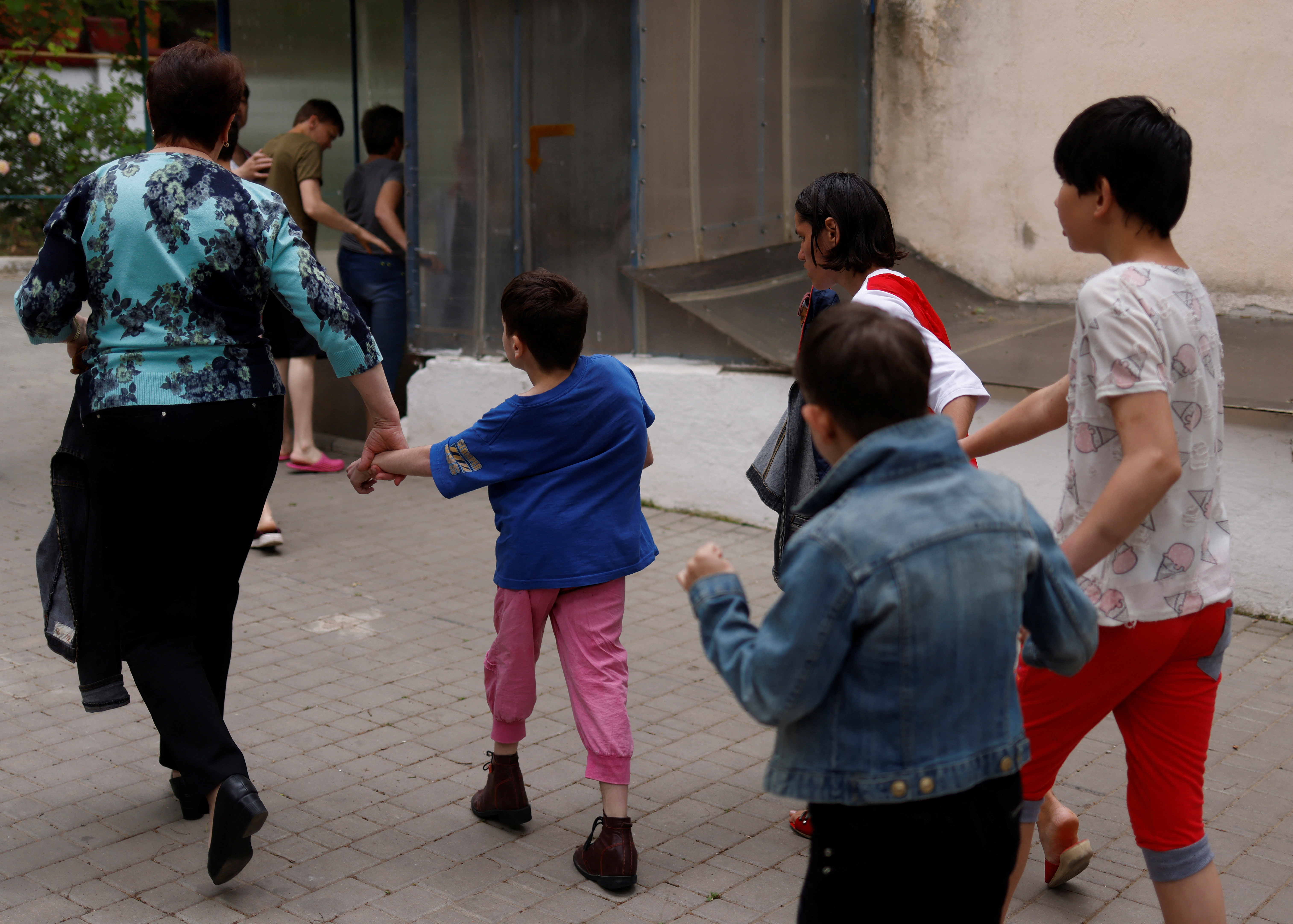 Una maestra lleva a los niños a un refugio en el sótano cuando suena una advertencia de ataque aéreo en un centro para personas con necesidades especiales, en medio de la invasión rusa de Ucrania, en Odesa. (REUTERS/Edgar Su)