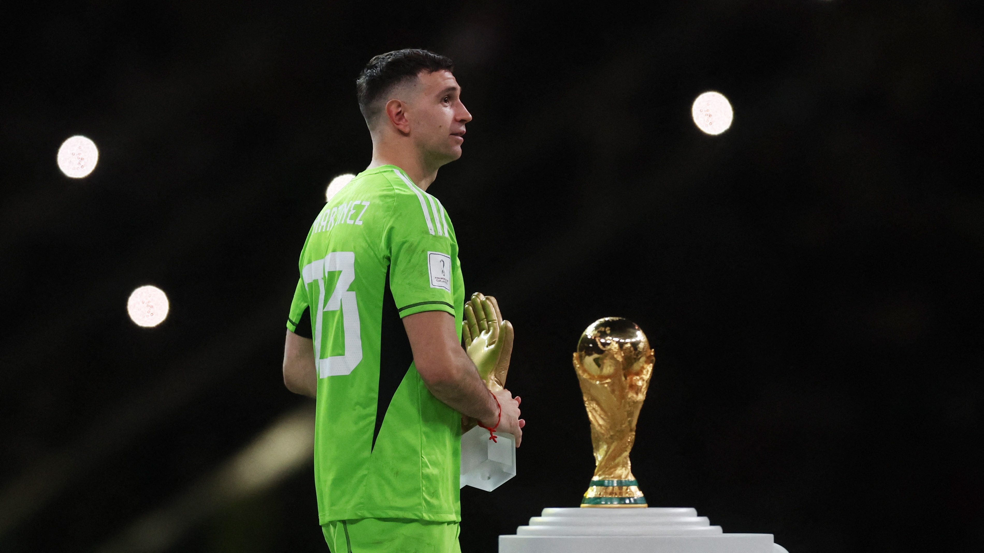Soccer Football - FIFA World Cup Qatar 2022 - Final - Argentina v France - Lusail Stadium, Lusail, Qatar - December 18, 2022 Argentina's Emiliano Martinez walks pass the FIFA World Cup trophy after he is awarded the golden glove award during the trophy ceremony REUTERS/Lee Smith
