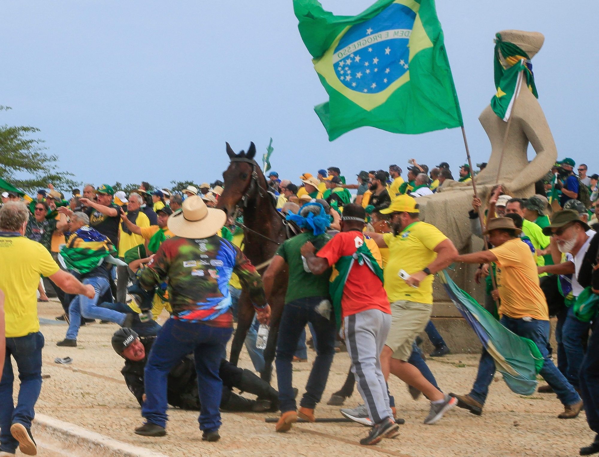 Un oficial de la Policía Militar cae de su caballo durante enfrentamientos con partidarios del expresidente brasileño Jair Bolsonaro luego de una invasión al Palacio Presidencial de Planalto en Brasilia el 8 de enero de 2023. AFP