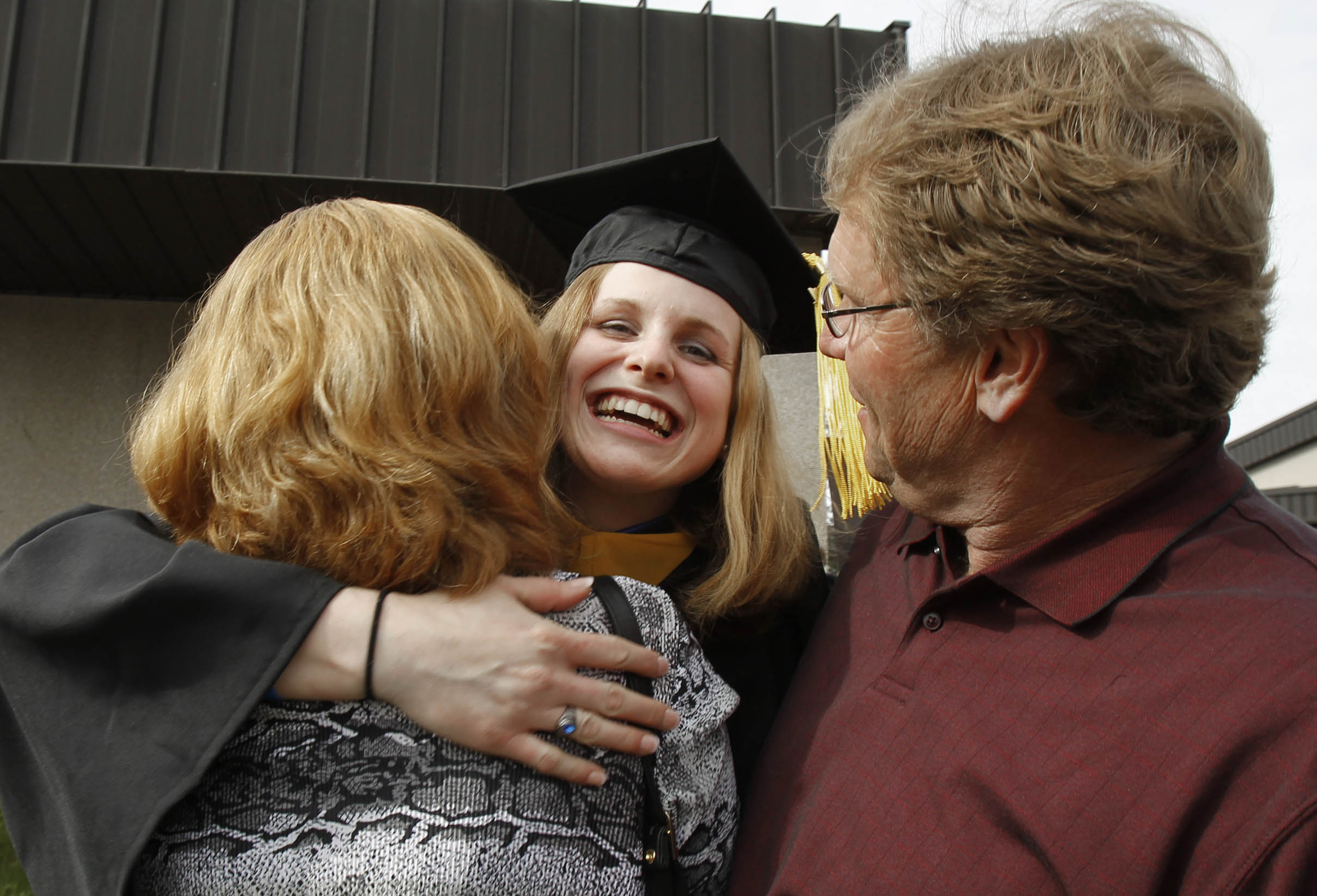 Jeanna Giese sonríe y abraza a sus padres Anne y John durante su graduación (Photo by Rick Wood/Milwaukee Journal Sentinel/MCT/Sipa USA)