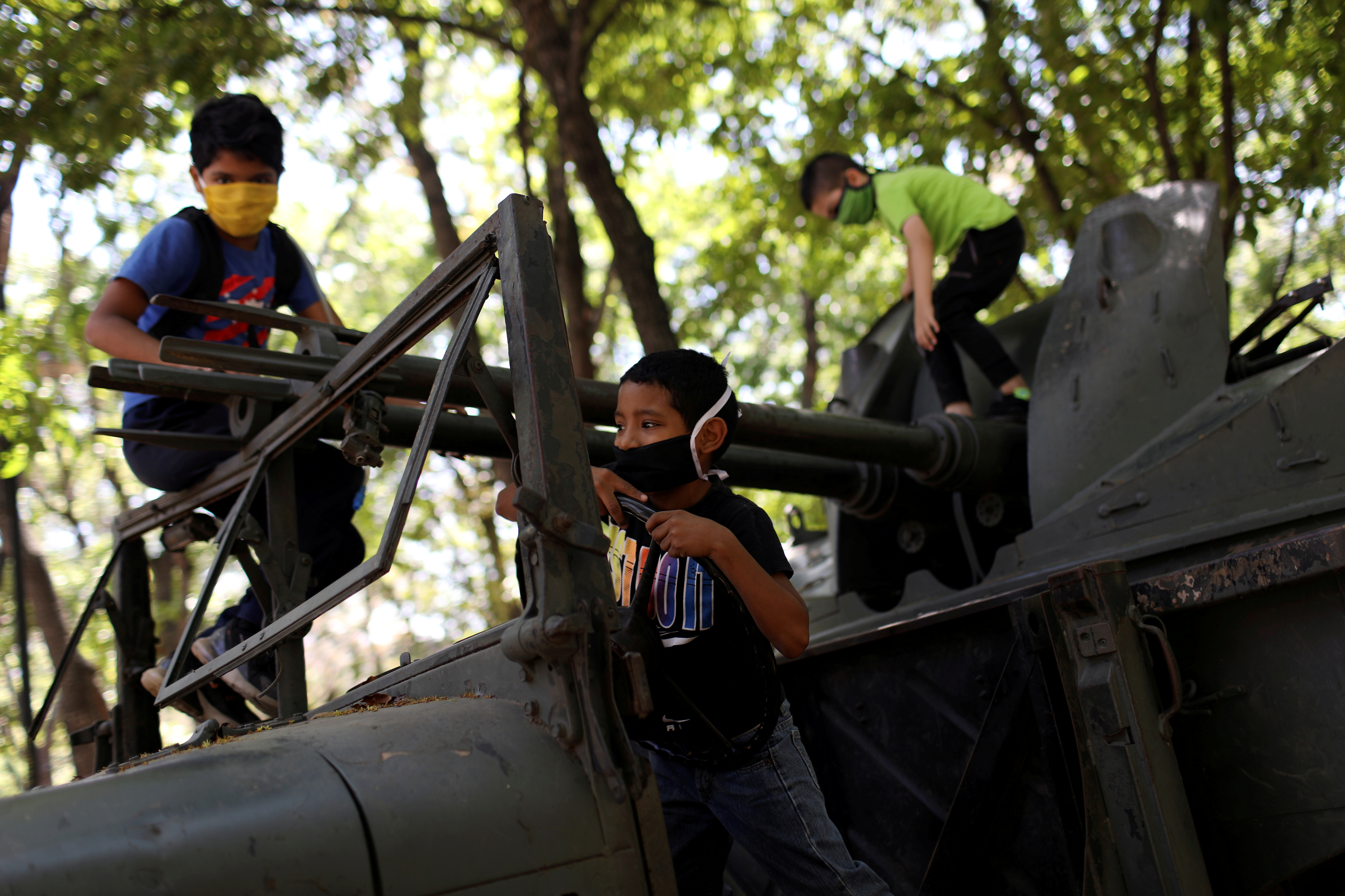 Niños venezolanos juegan en un tanque no operativo en el bulevar Los Proceres en Caracas durante el permiso de 8 horas para que los menores de 14 años salgan al exterior el 26 de abril de 2020 (REUTERS/Manaure Quintero)