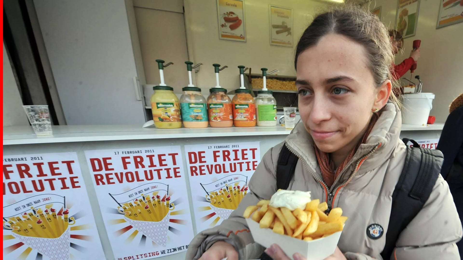 A woman eats french fries with mayonnaise on the day of the French potato revolution in Leuven, February 17, 2011 (AFP)