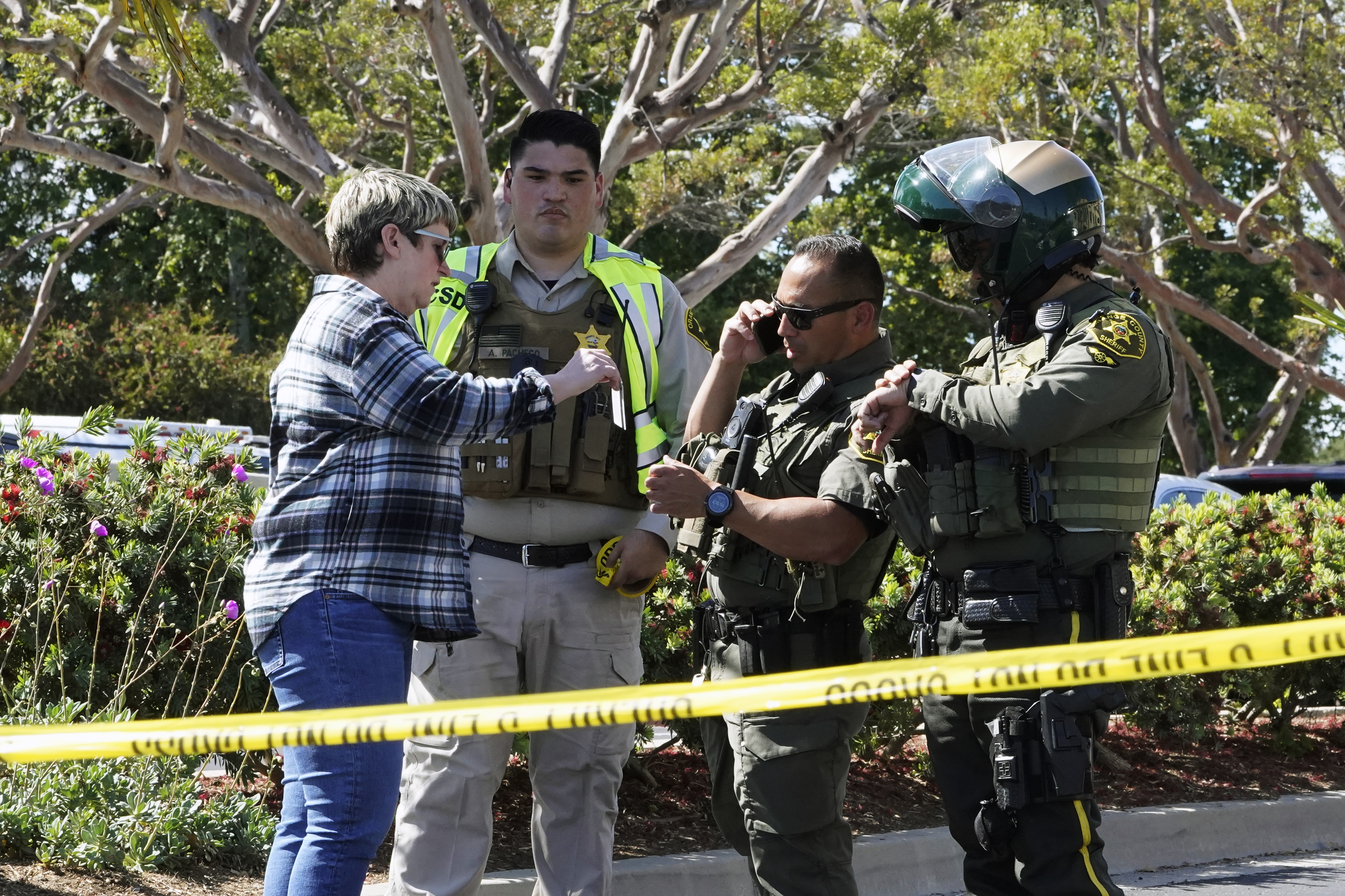 Orange County sheriff's deputies verify the identity of a person trying to gain access to a church parking lot after the fatal shooting (AP Photo/Damián Dovarganes)