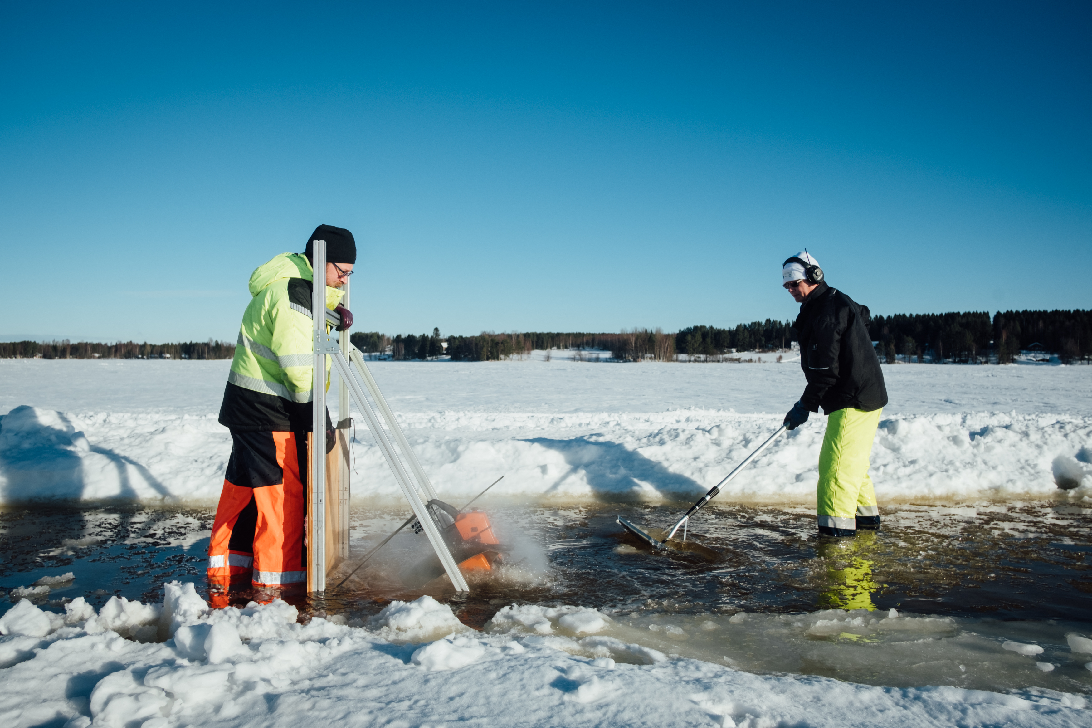 Dos personas usan una herramienta especialmente diseñada para cortar el hielo (Alessandro RAMPAZZO / AFP)
