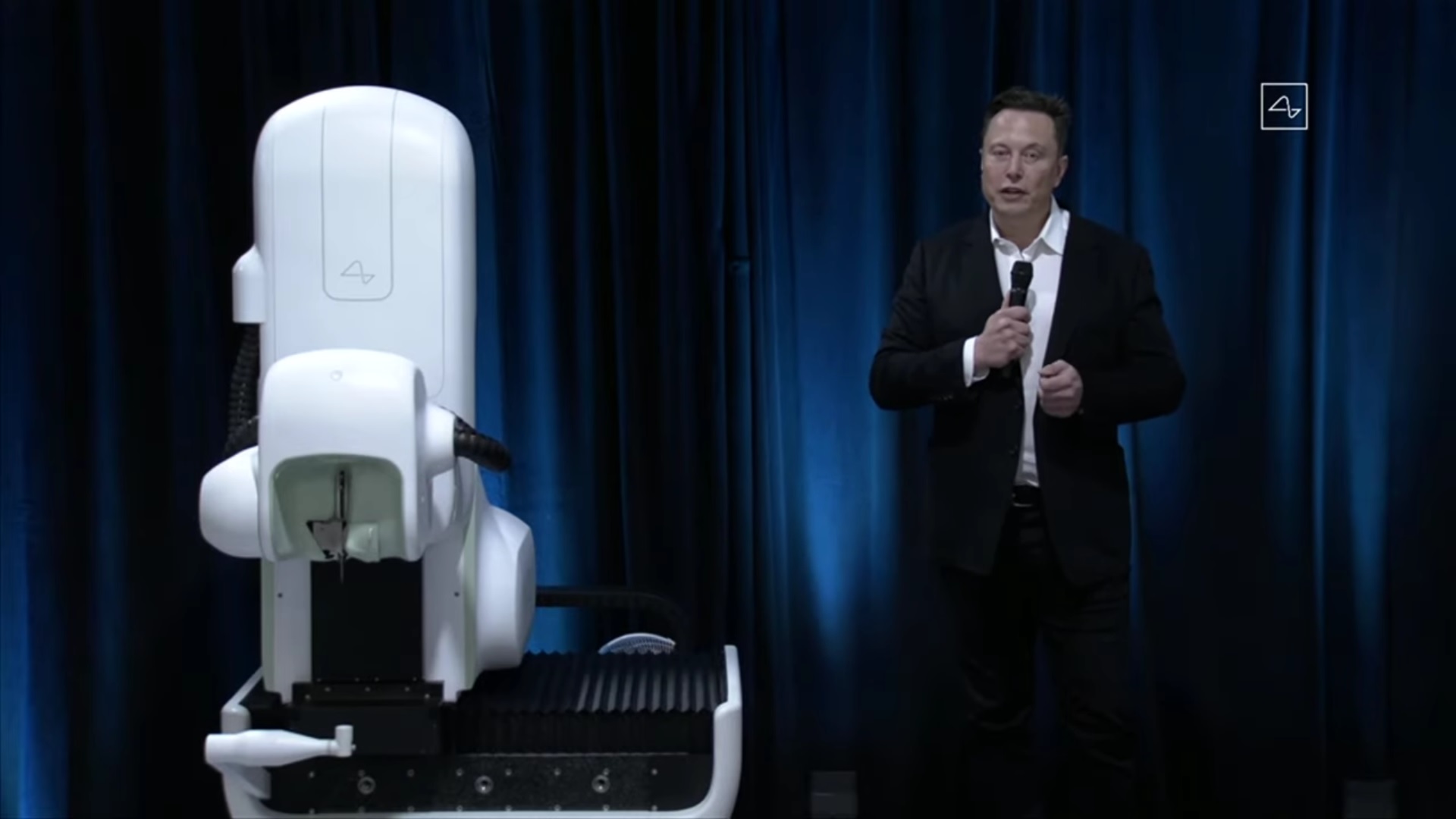 Elon Musk junto al robot que se utilizaría en las cirugías para insertar los chips