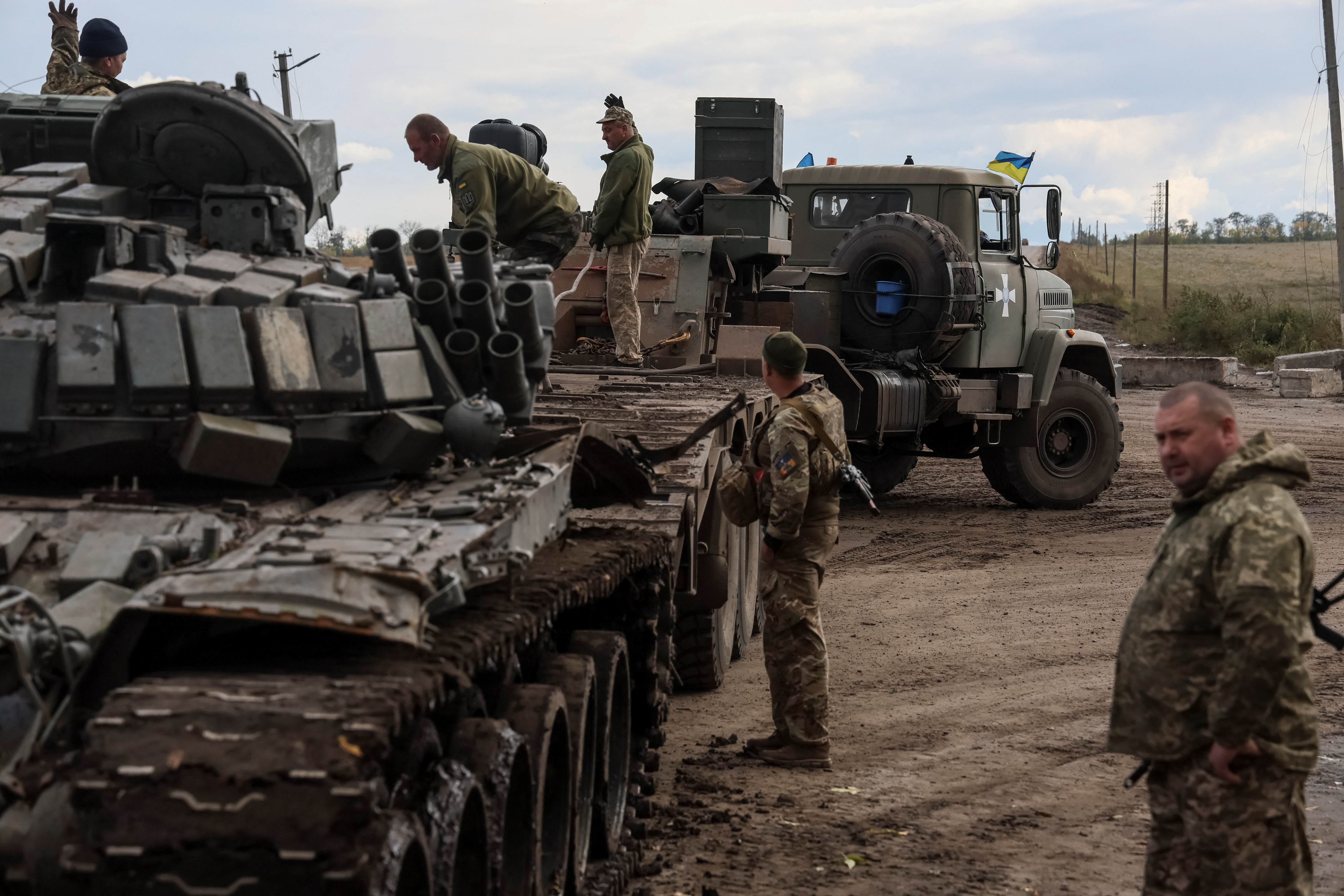 Militares ucranianos cargan un tanque ruso destruido en un camión, en la ciudad de Izium, recientemente liberada por las Fuerzas Armadas de Ucrania, en la región de Kharkiv, Ucrania 24 de septiembre de 2022.  REUTERS/Gleb Garanich