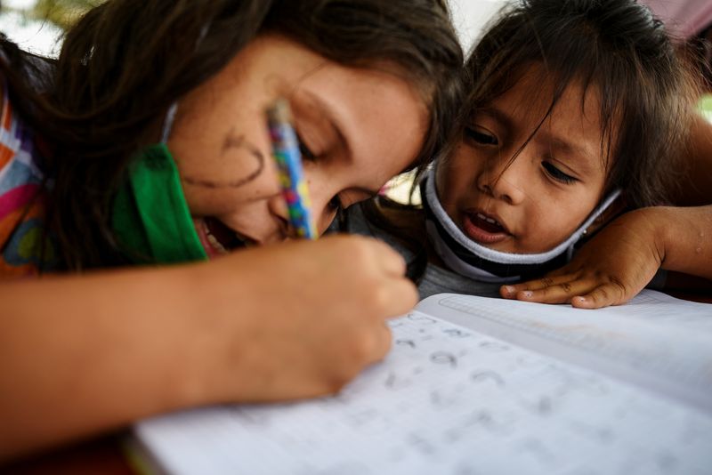 Dos niños haciendo cuentas en una tarea de matemática en la improvisada escuela de Denisse Toala en el barrio Realidad de Dios, en Guayaquil. (REUTERS/Santiago Arcos)