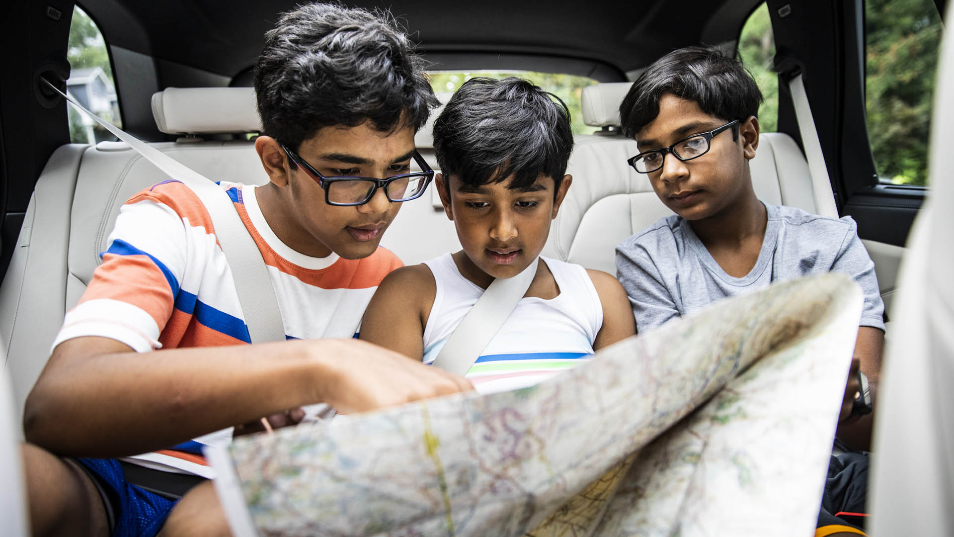 Si no se marean en movimiento, leer un mapa durante el viaje es un buen modo de entretener a los chicos si se quiere pausar el uso de electrónica a bordo / Getty
