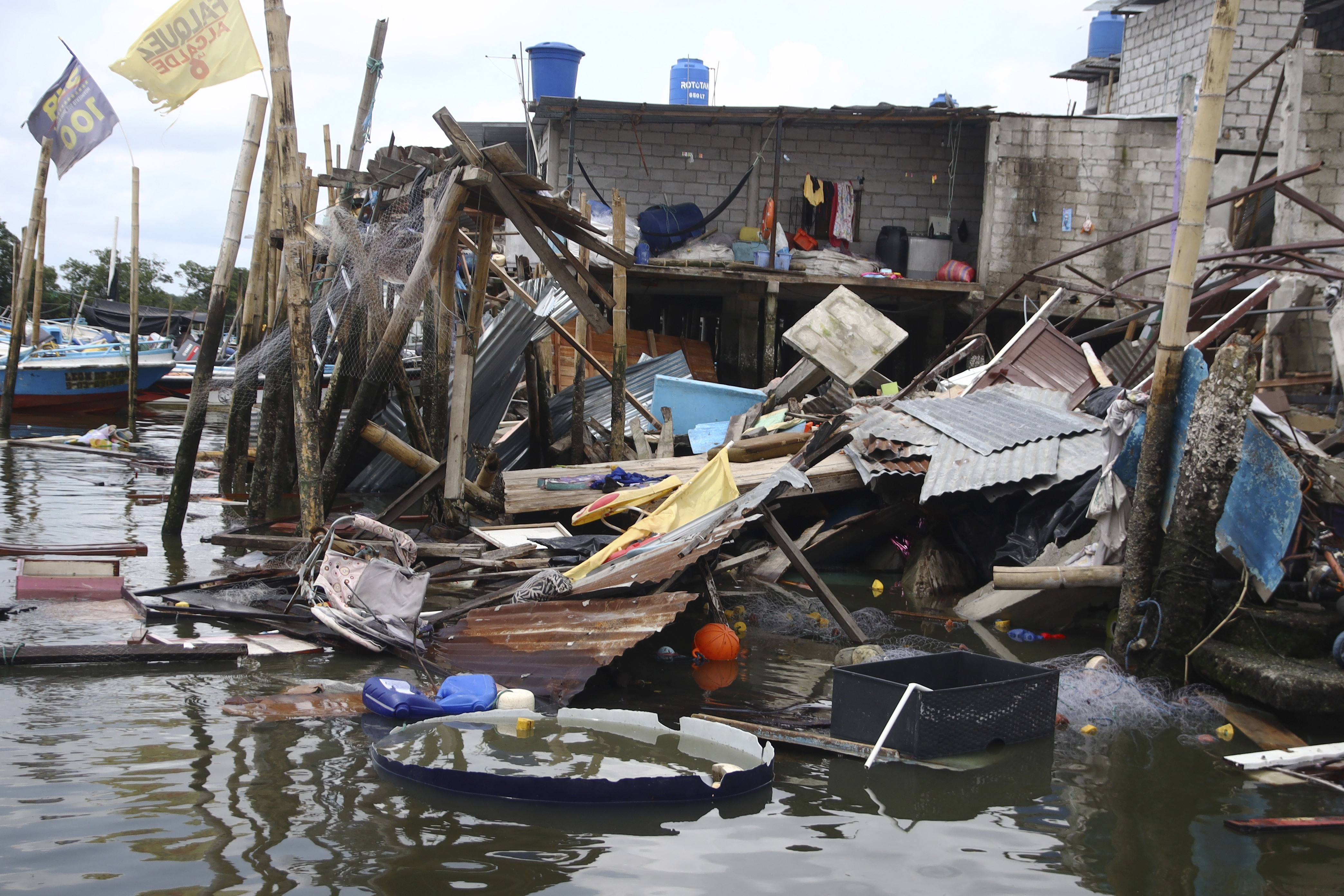 Casa derrumbada sobre el agua tras un terremoto que sacudió la costa de Ecuador, en el poblado de Puerto Bolívar, Ecuador, el domingo 19 de marzo de 2023. (Foto AP/César Muñoz)