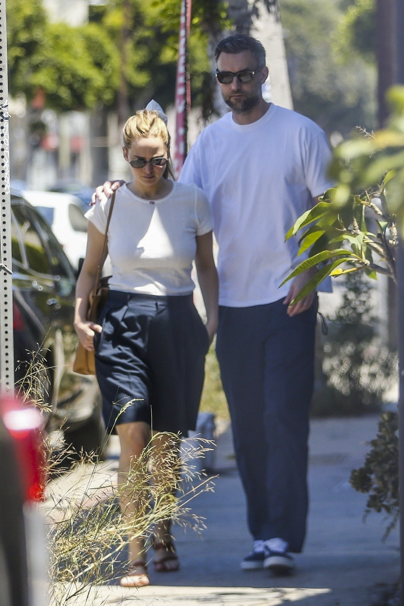 Jennifer Lawrence and Cooke Maroney were photographed as they toured mansions in the West Hollywood area looking for a new home to move into.  She wore blue shorts with a classic white t-shirt and brown sandals that she paired with her leather bag.  He wore a similar look: long blue pants and a white shirt.
