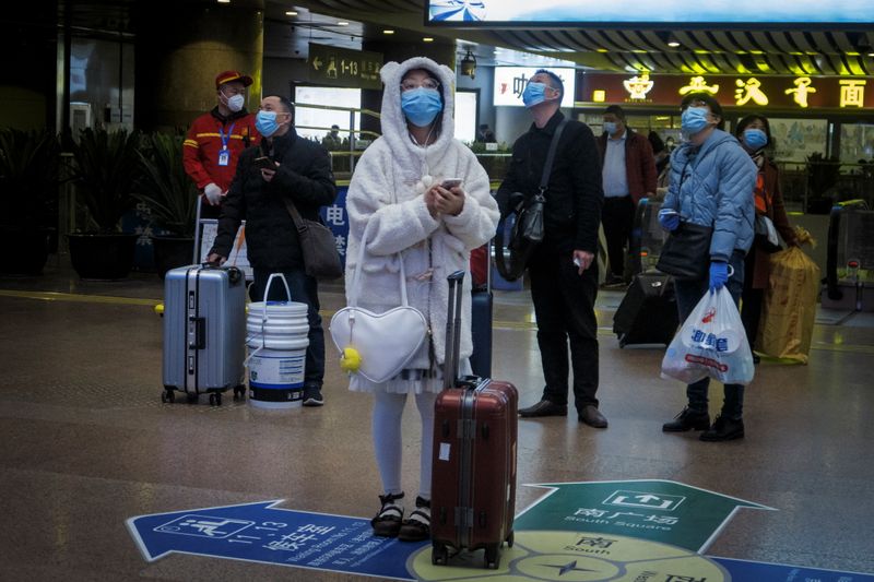 Viajeros usan mascarilla en una estación de trenes luego del brote de coronavirus en Pekín (REUTERS/Thomas Peter)