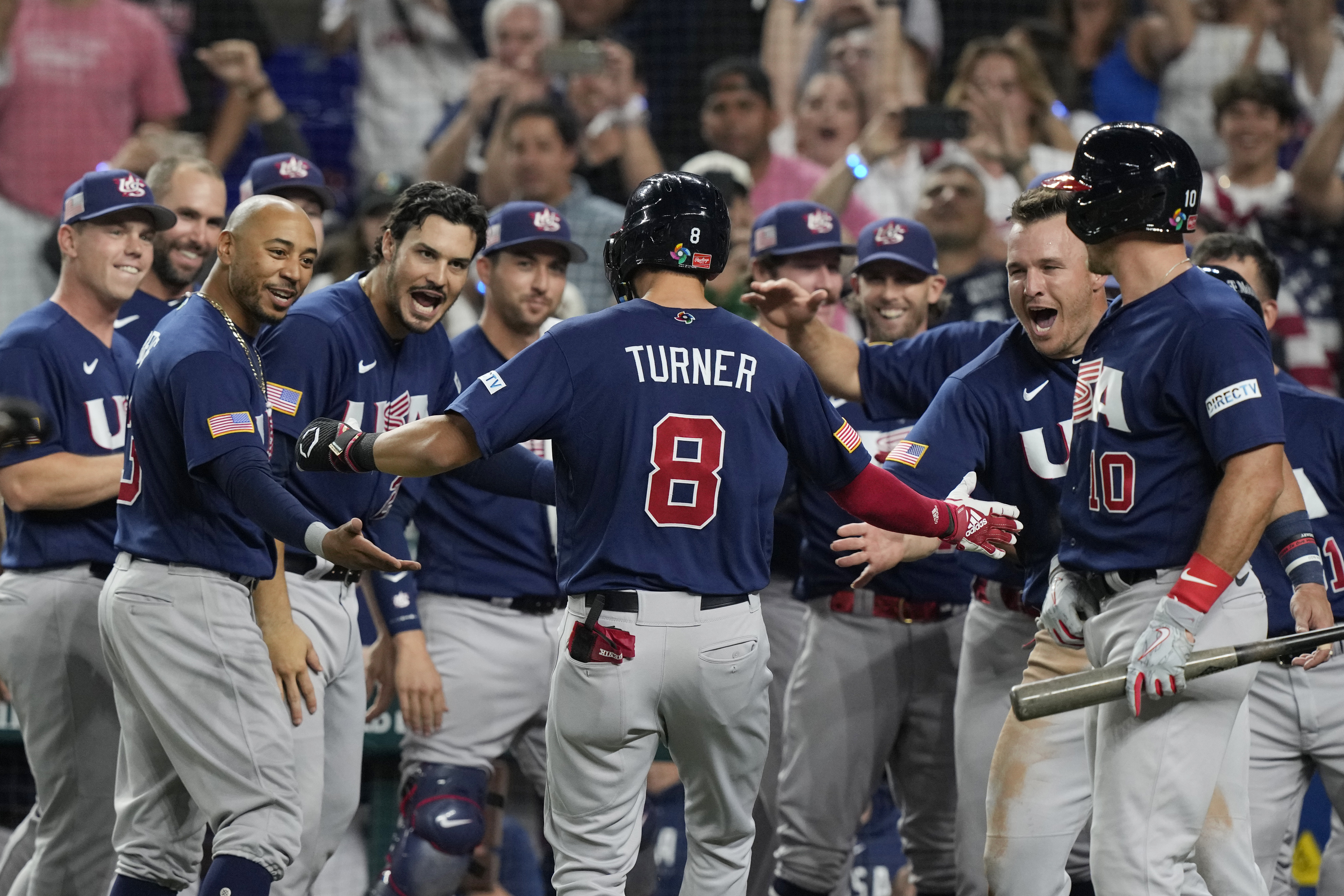 Trea Turner (8) is congratulated by teammates from the United States after hitting a home run against Japan in the final of the World Baseball Classic, Tuesday, March 21, 2023, in Miami.  (AP PhotoMarta Lavandier)