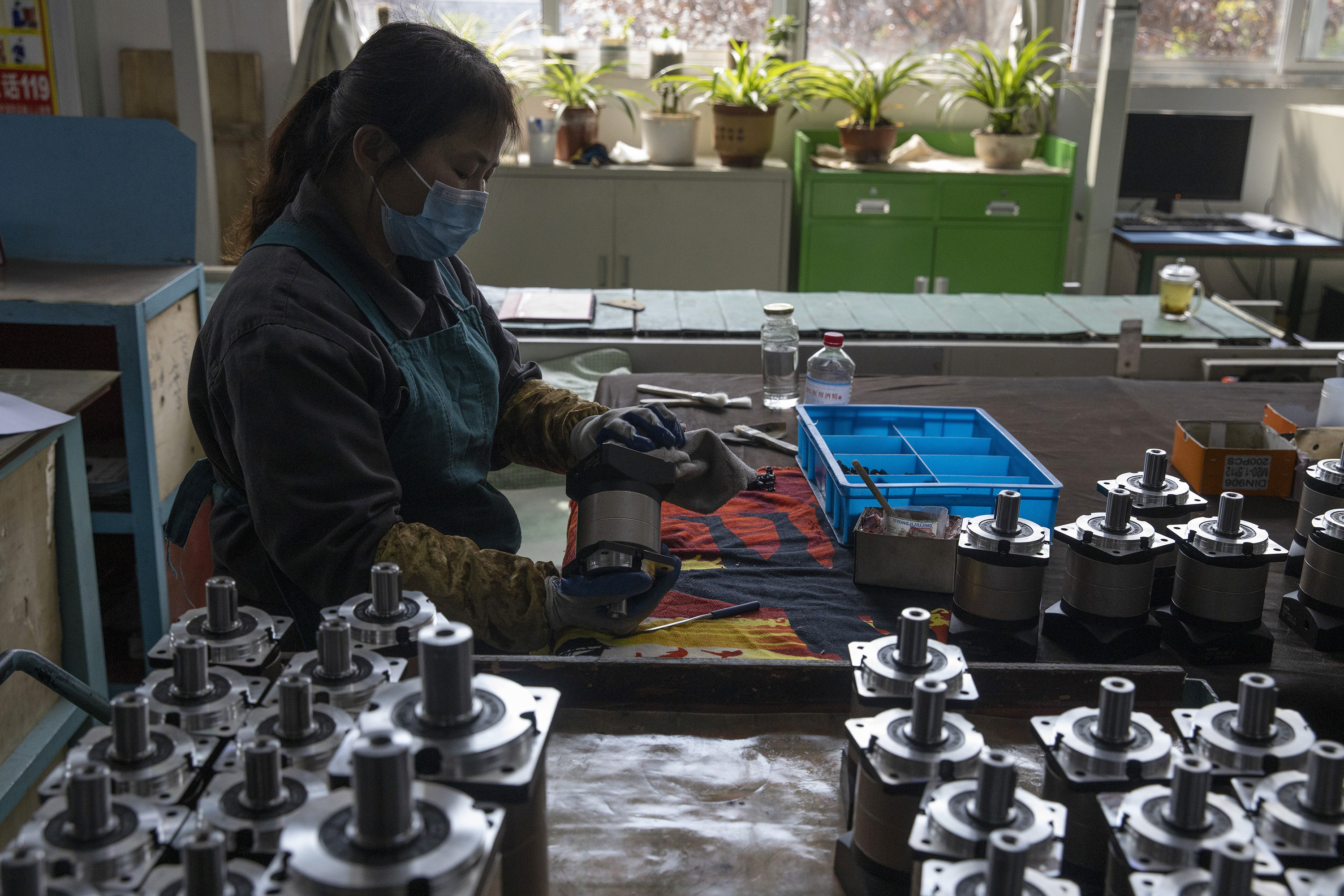 ARCHIVO - En esta fotografía de archivo del 13 de abril de 2020, una trabajadora ensambla cajas de cambios en la fábrica Kofon en Huanggang, en la provincia central china de Hubei. (AP Foto/Ng Han Guan, archivo)