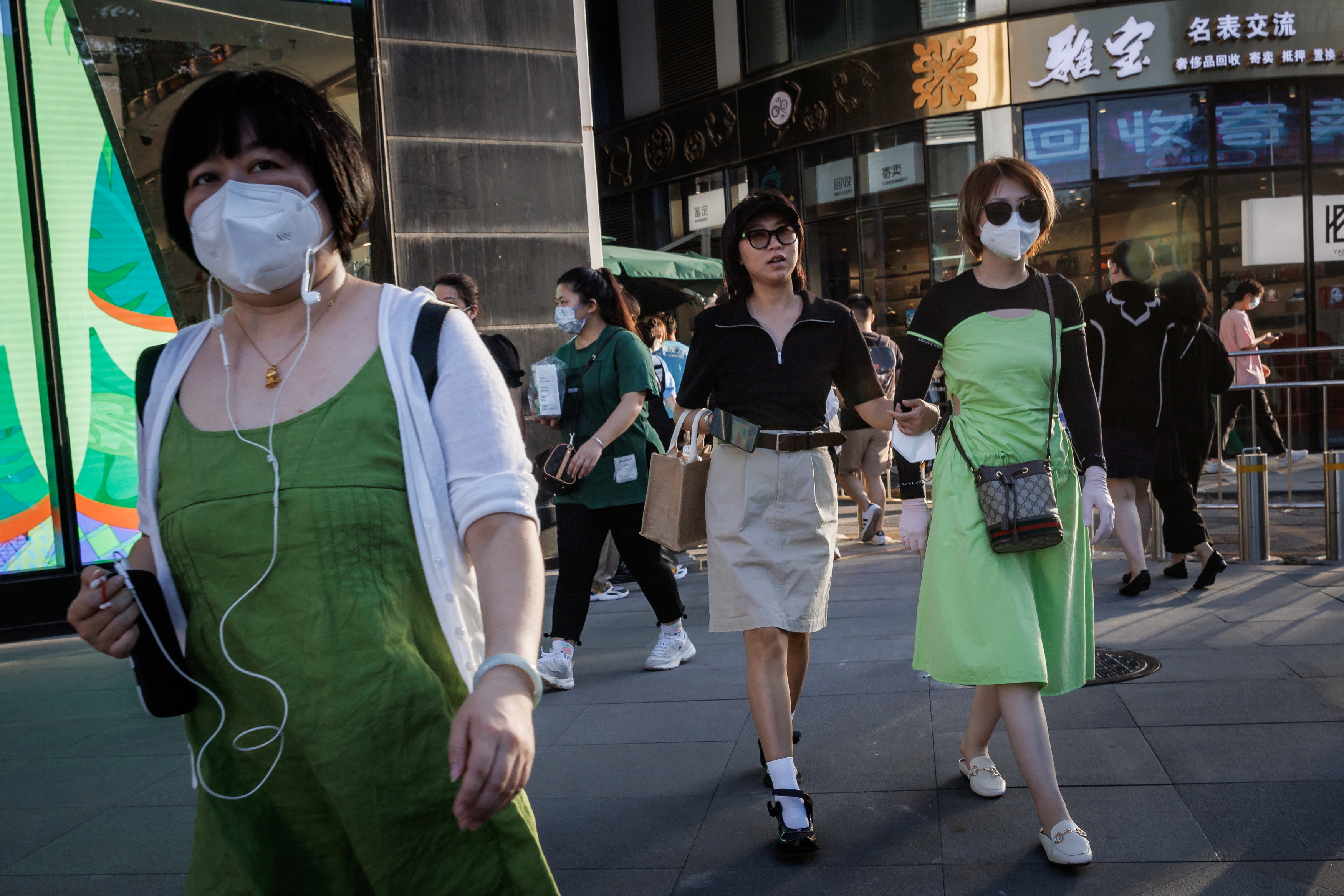 Mujeres caminan en un distrito comercial de la capital china (Reuters)