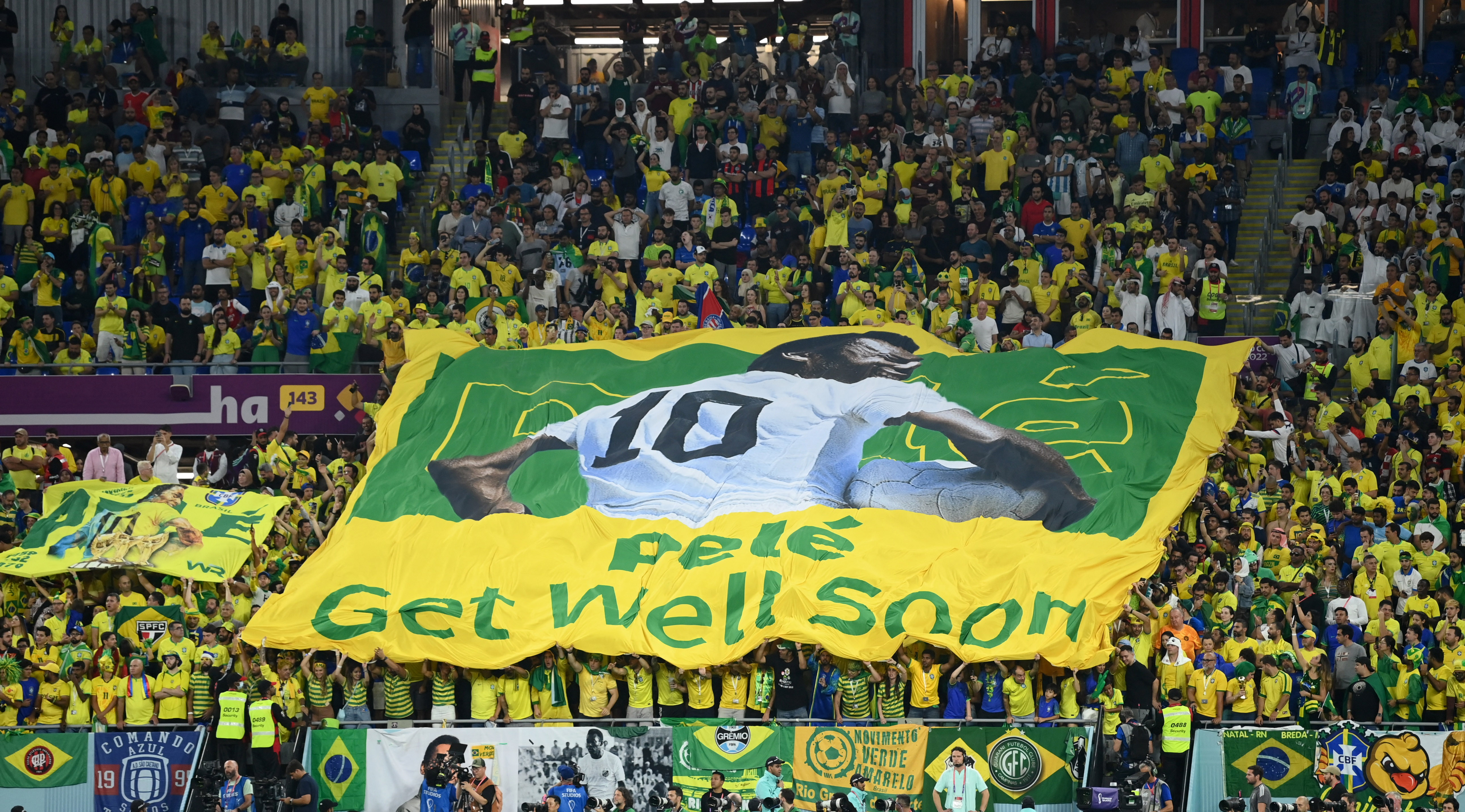 Soccer Football - FIFA World Cup Qatar 2022 - Round of 16 - Brazil v South Korea - Stadium 974, Doha, Qatar - December 5, 2022  Fans inside the stadium hold up a banner of former Brazil player Pele with the message get well soon REUTERS/Annegret Hilse